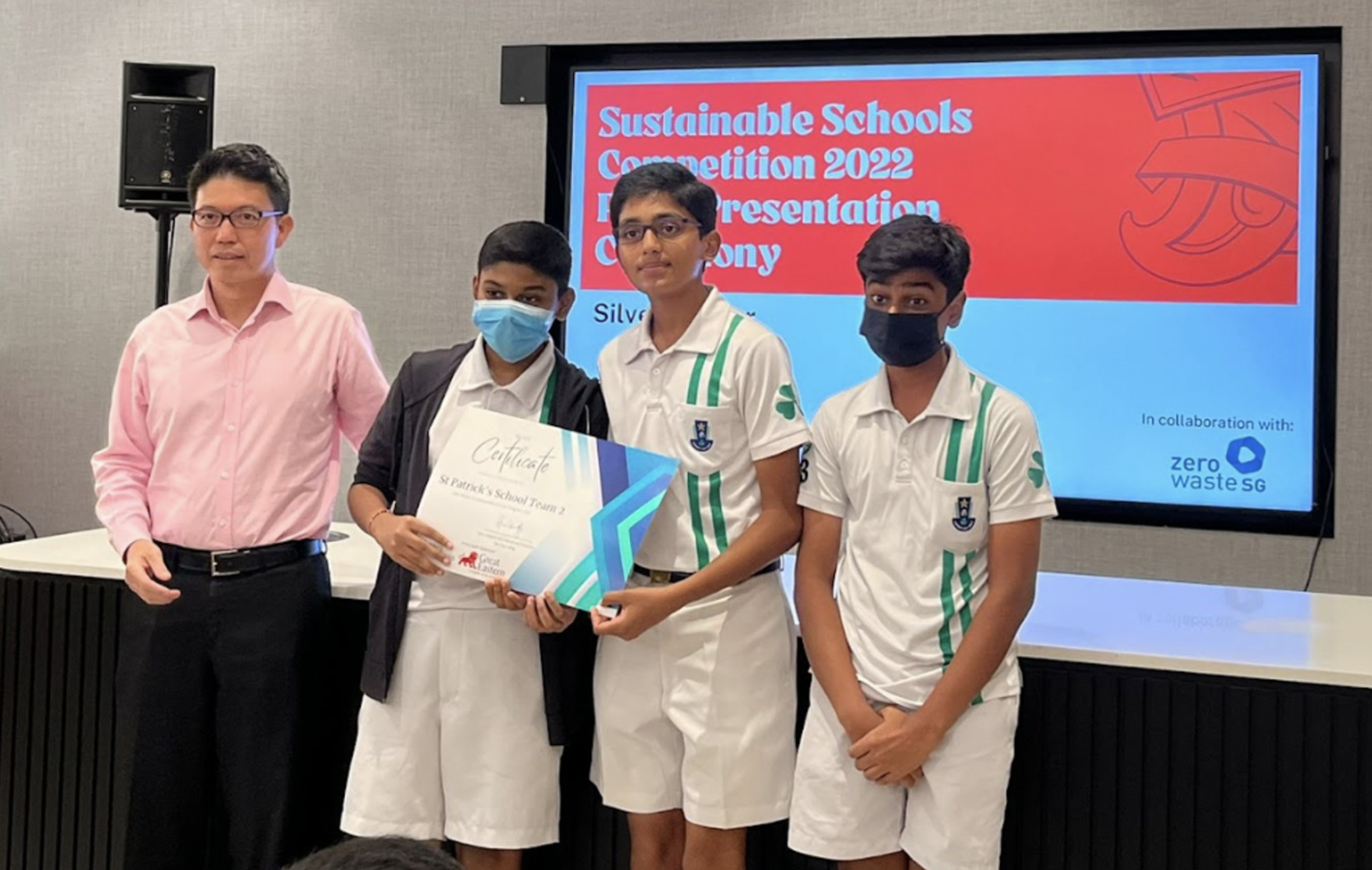 Four people pose with a certificate before a screen reading Sustainable Schools Competition 2022.