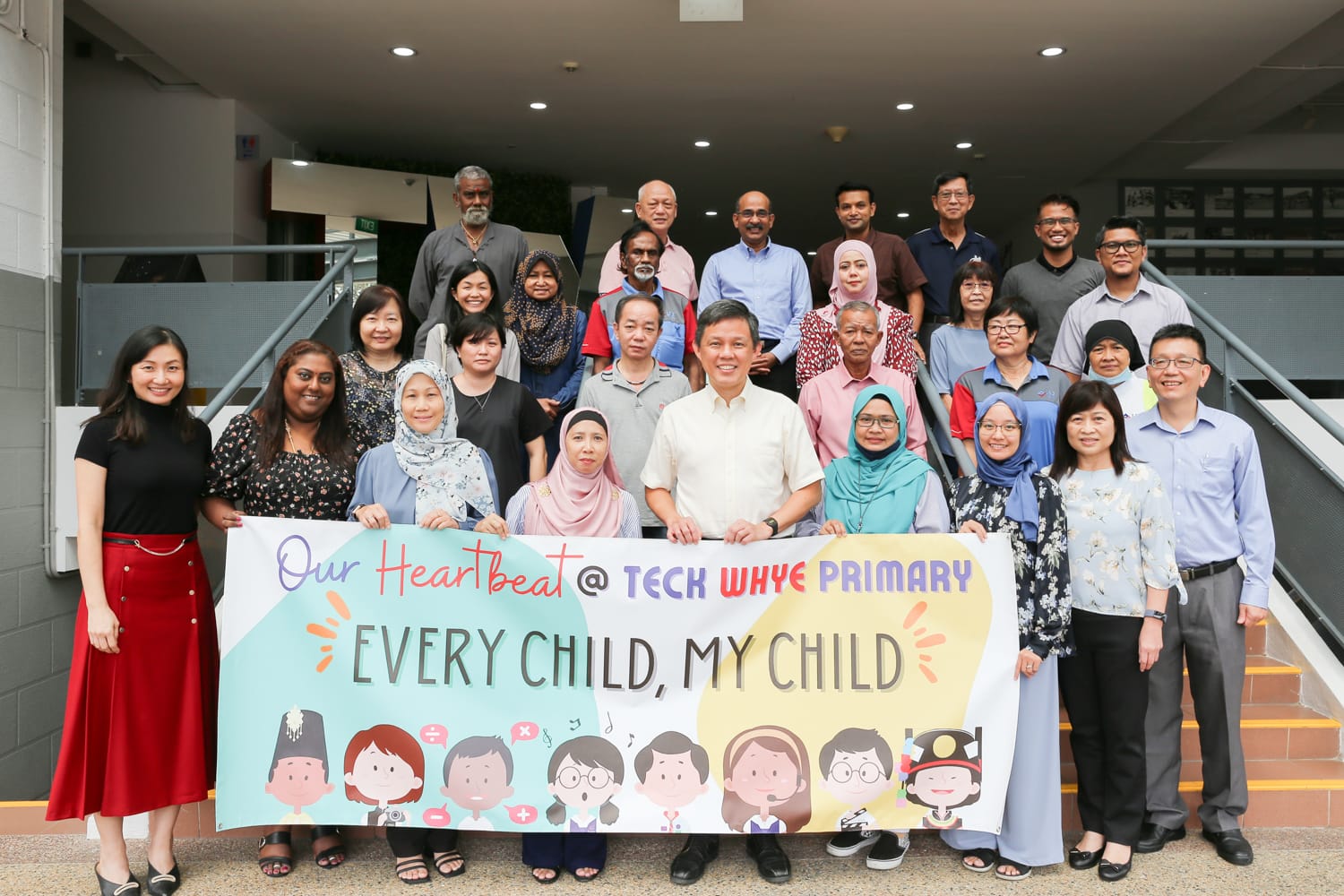 Group photo of Minister Chan Chun Sing with key members of the Teck Whye Primary School community, including cleaners, school bus drivers, security guards and parent volunteers.