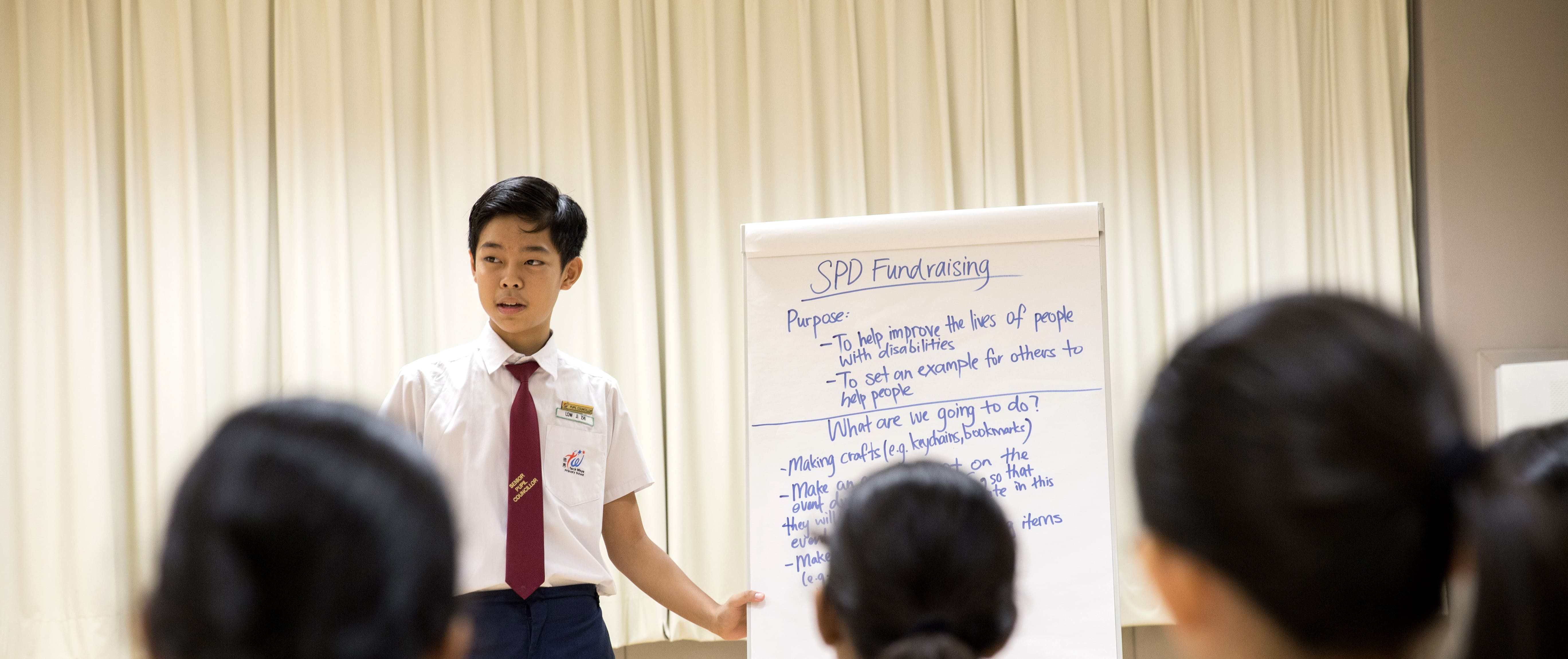 Alfred presenting a fundraising proposal to his peers as part of his leadership role in school.