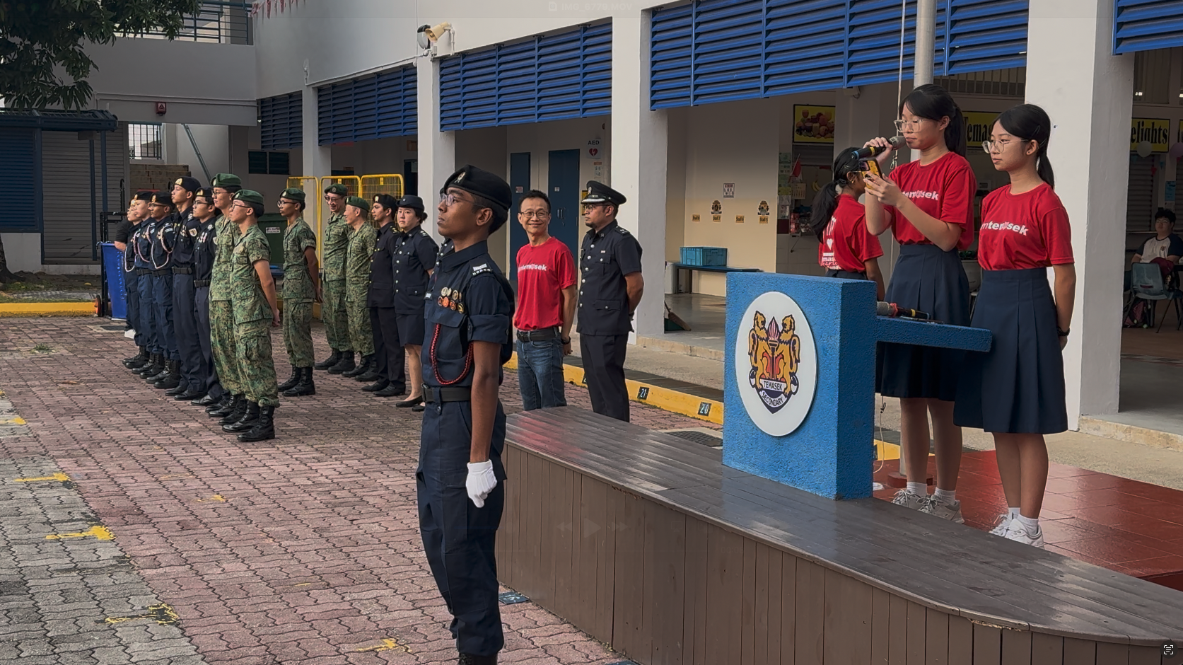 Students in uniforms stand at attention in a school courtyard during a formal ceremony at Temasek Secondary.