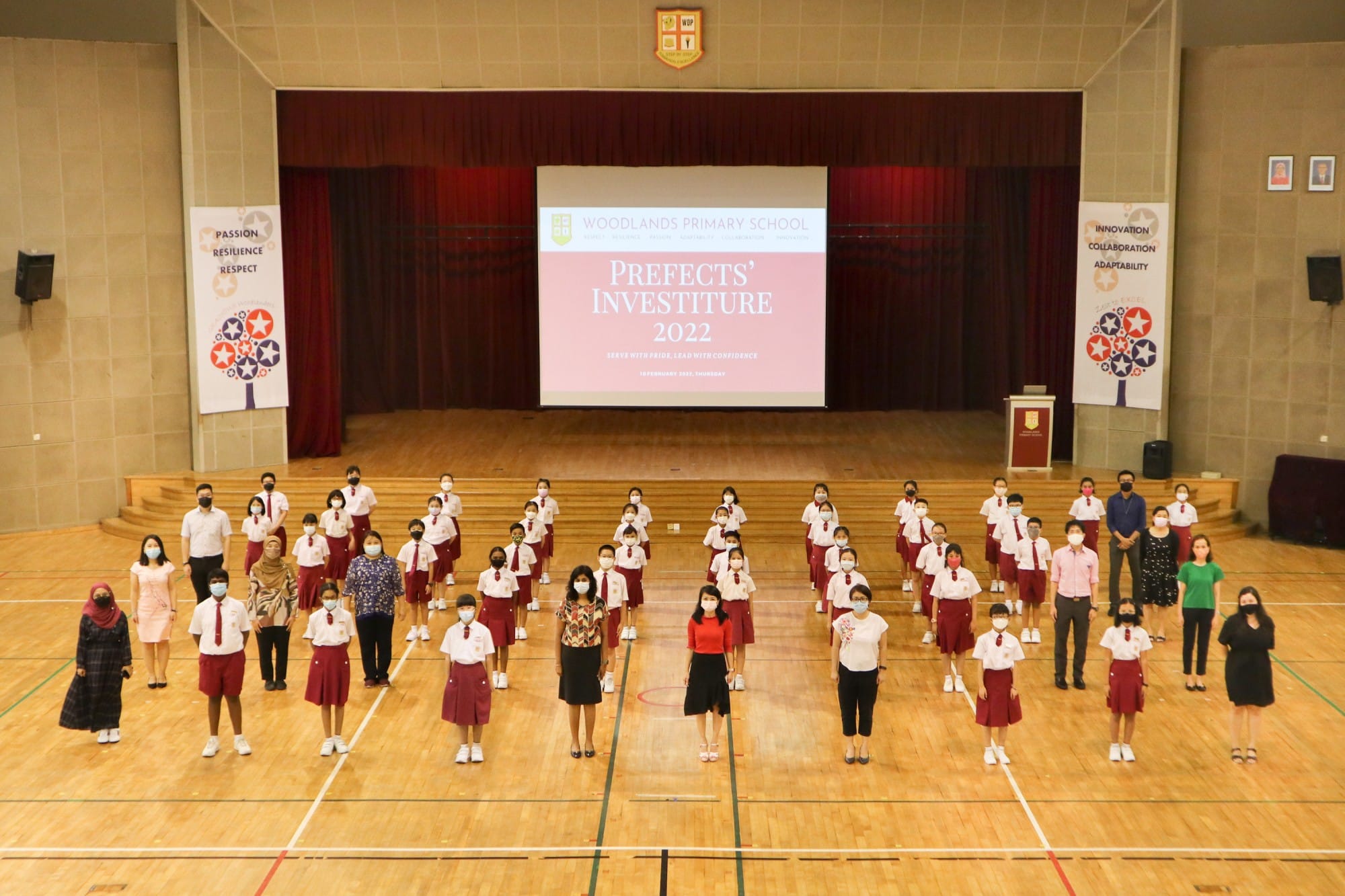 Students and teachers in a school hall at Woodlands Primary School Prefects Investiture 2022 ceremony.