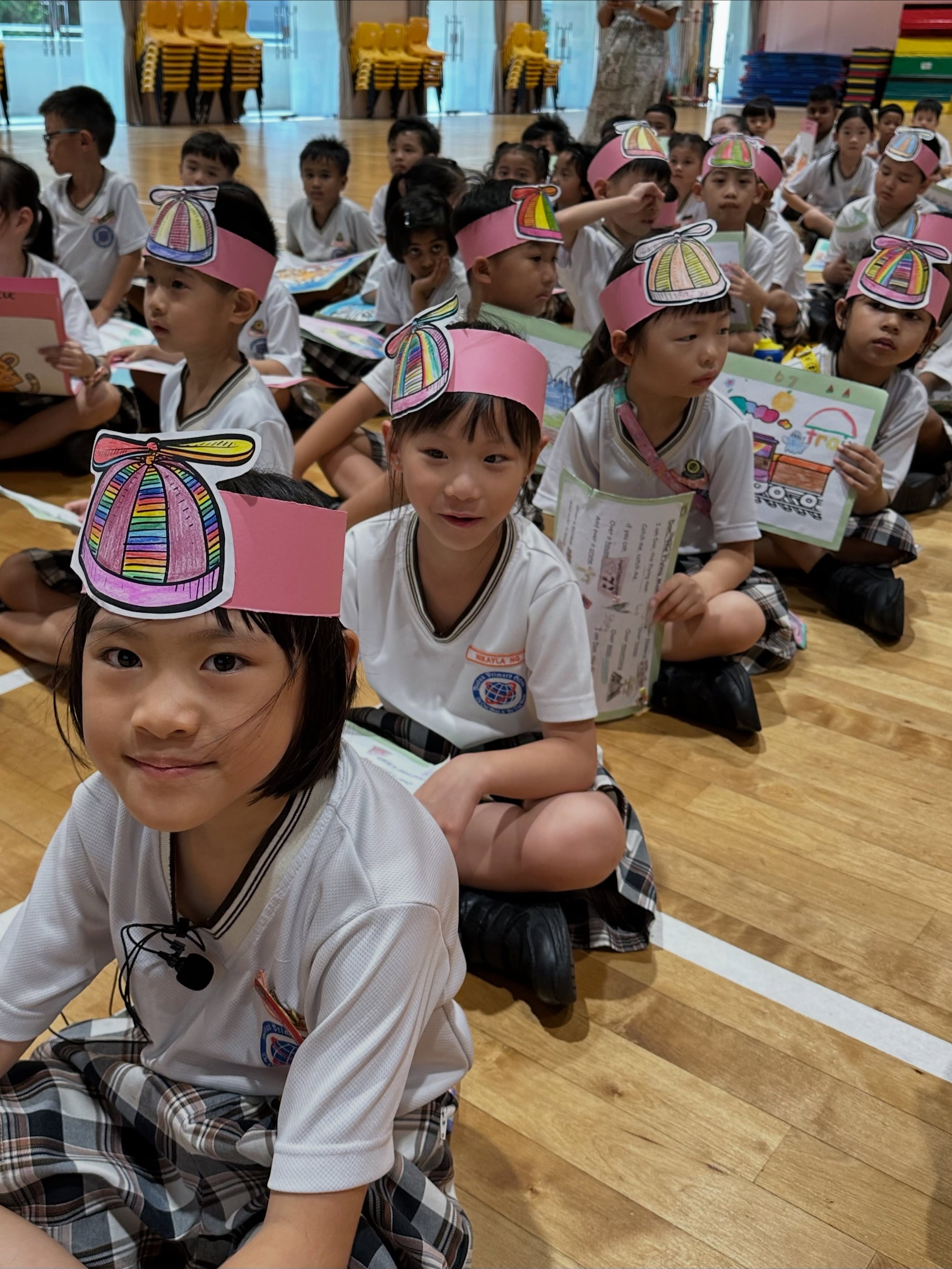 Students wearing handmade caps while watching Celebration of Learning.