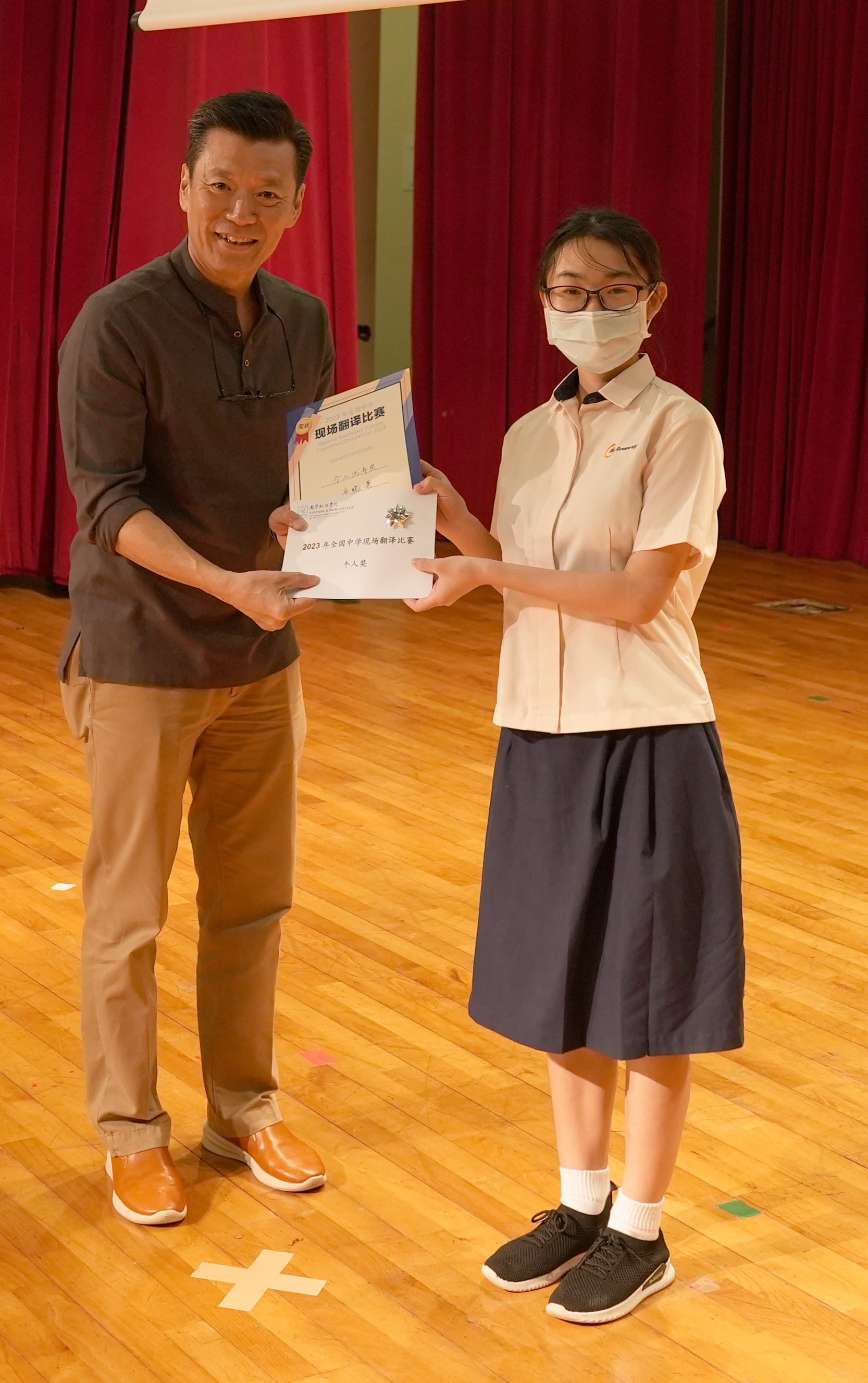 A Greenridge Secondary School student receives a certificate in recognition of an achievement at a Chinese language-related competition or programme, highlighting the student's dedication and accomplishment in language learning.