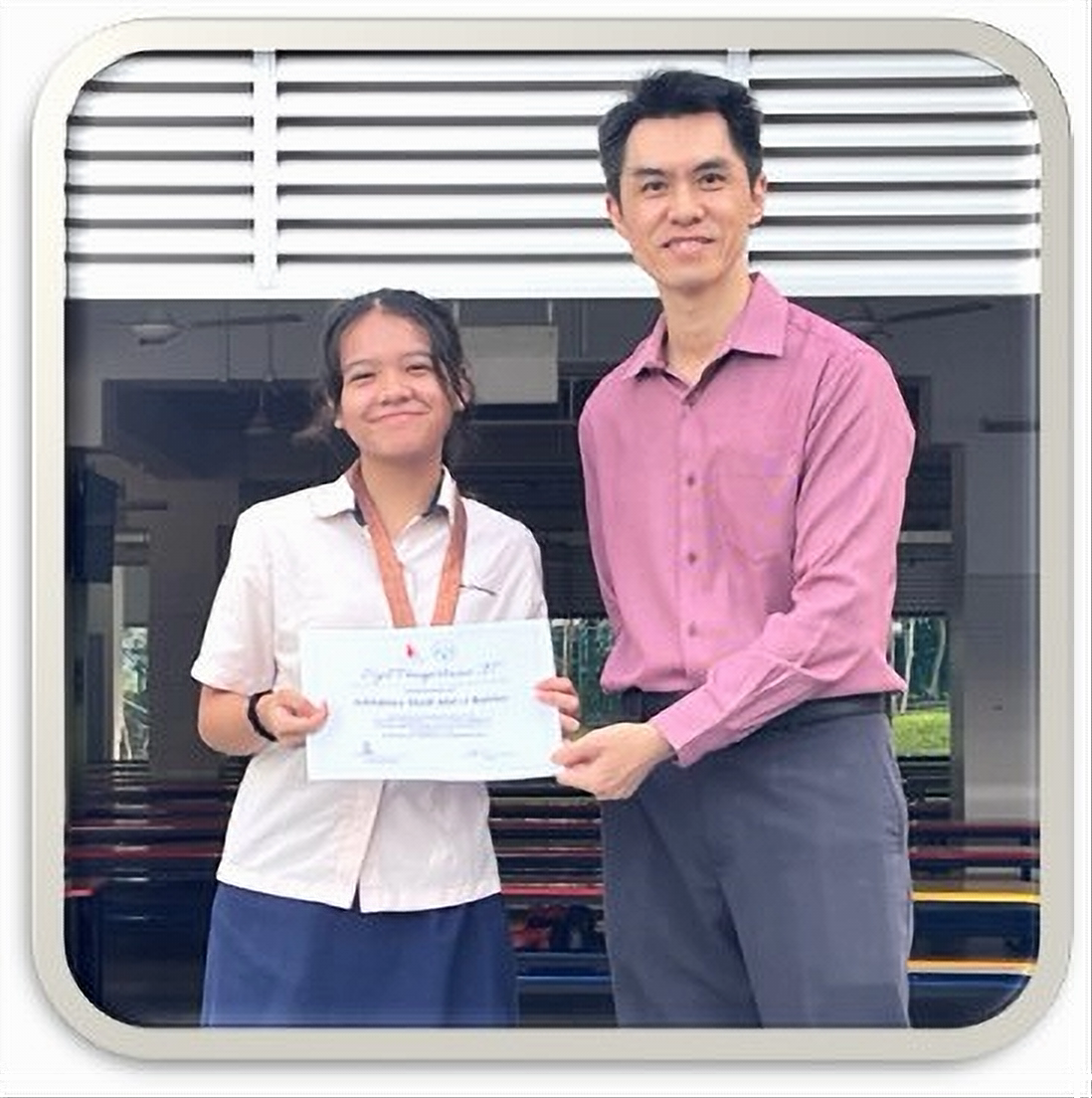 A Greenridge Secondary School student receives a certificate of recognition, highlighting an achievement in a school or external programme and celebrating the student's effort and accomplishment.