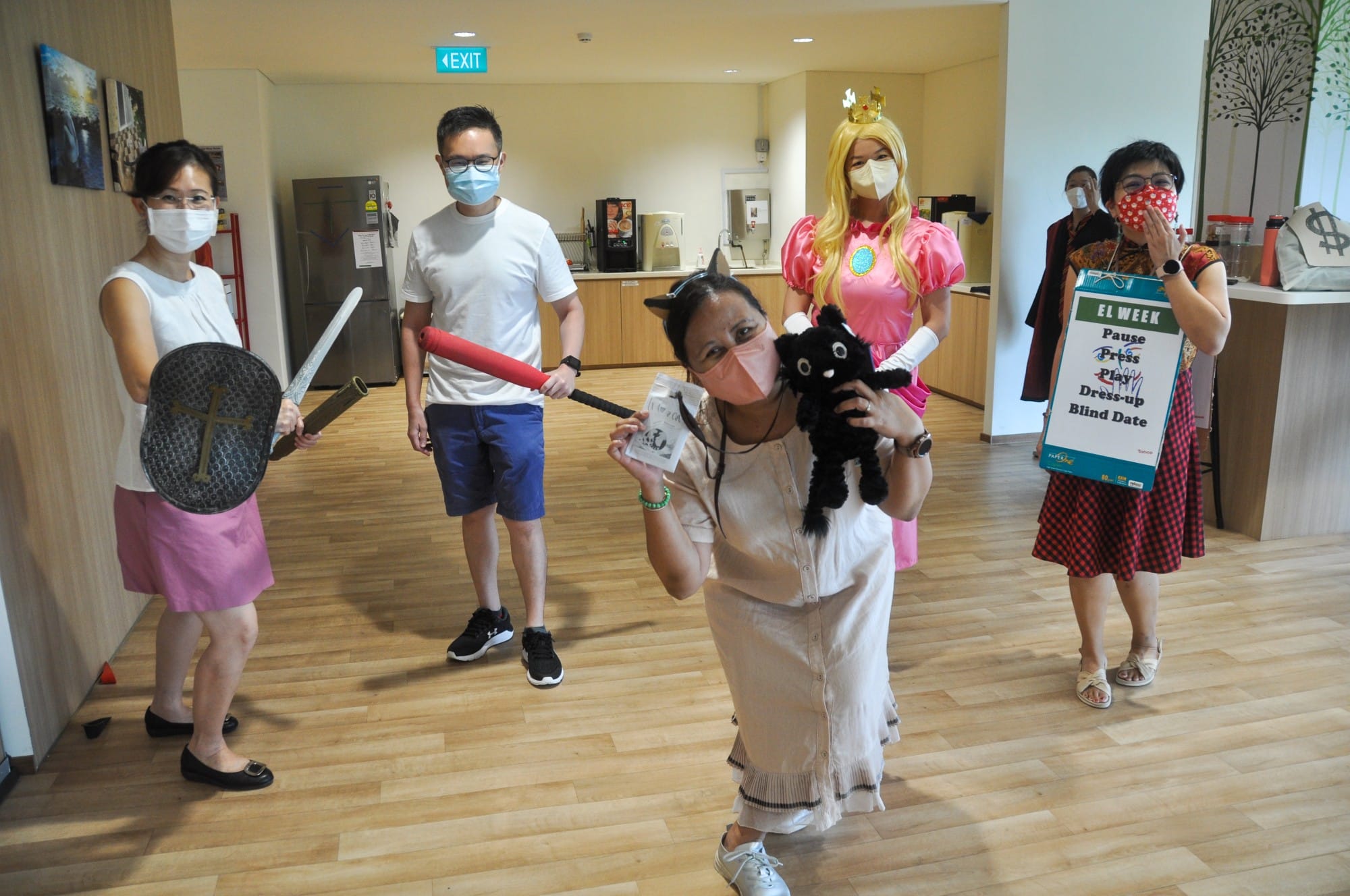 Five masked people in costumes pose indoors, one dressed as Princess Peach, others holding props like a sword and shield.