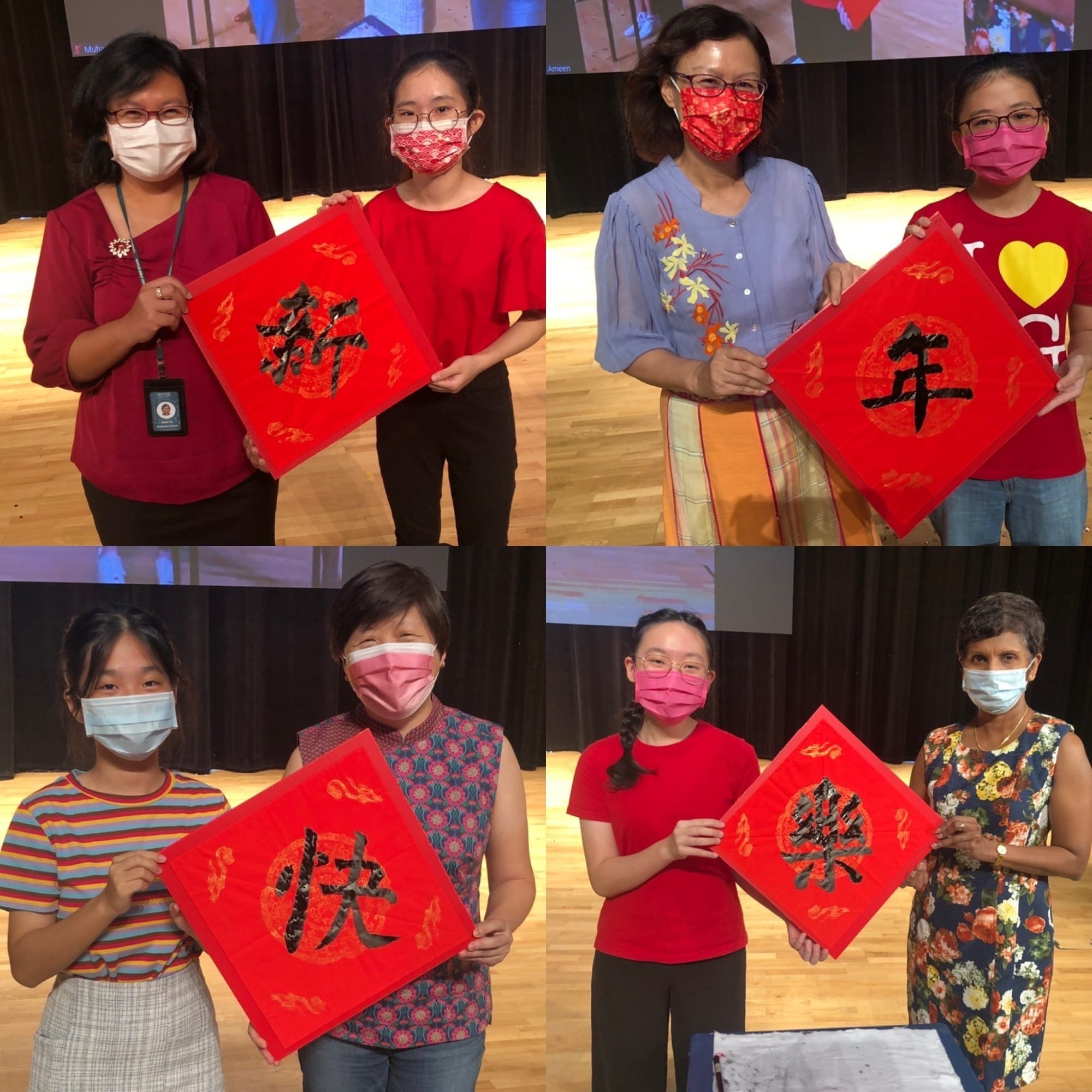 Six masked people pose in pairs, each holding red boards with black Chinese calligraphy characters on a stage.