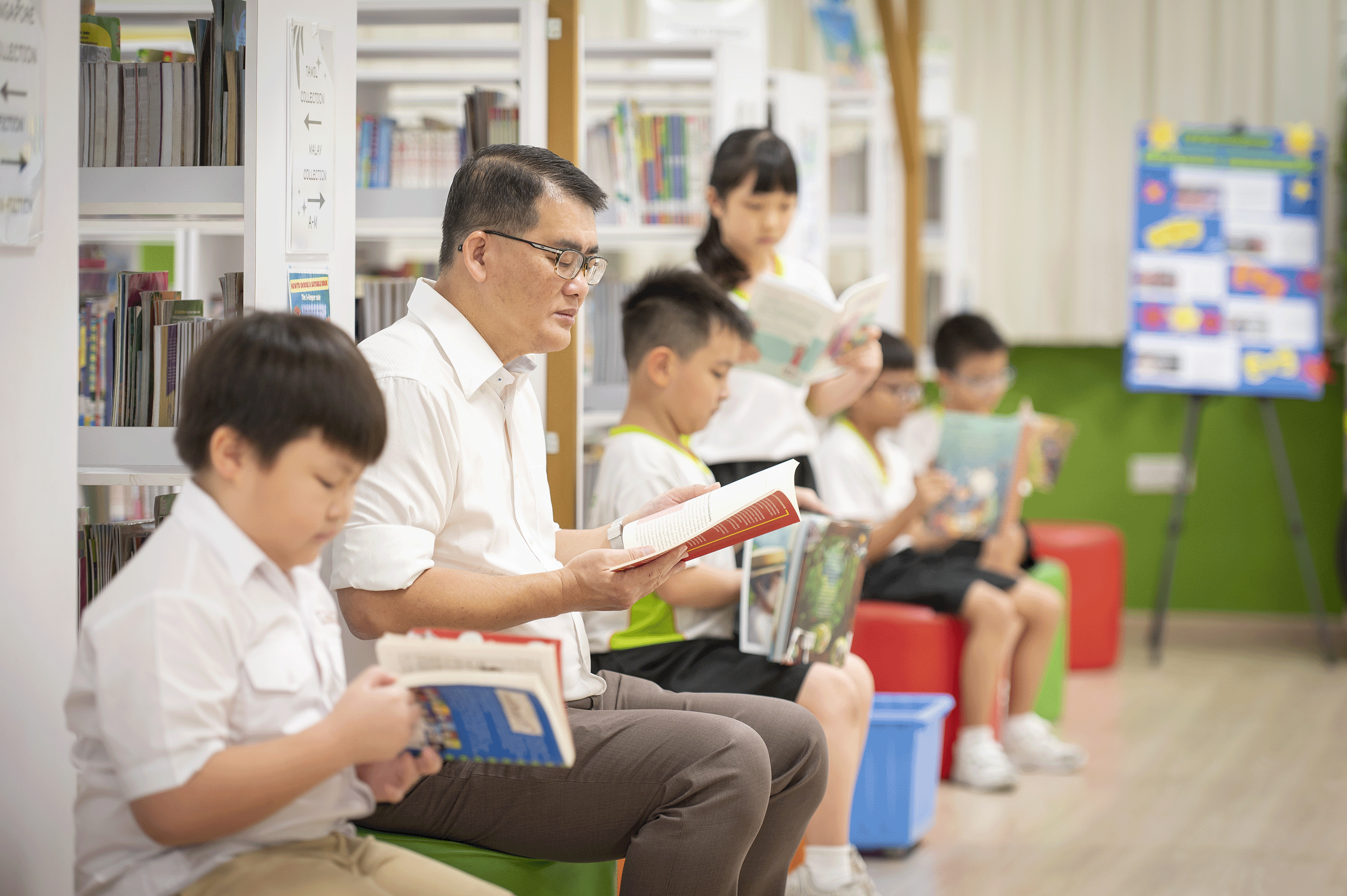 Mr Gau reading in the library
