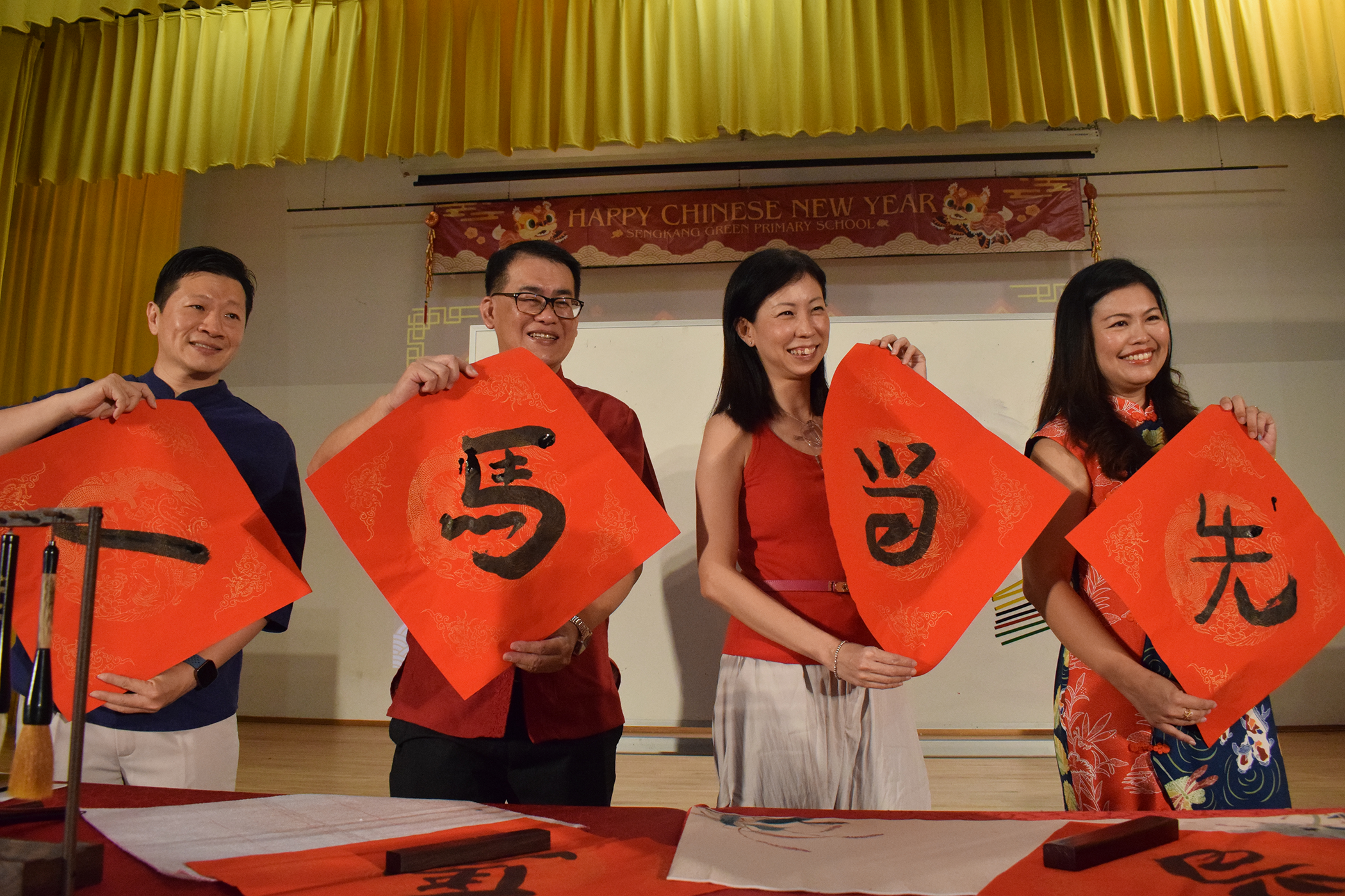 Principal Mr Gau with Chairman of Parent Support Group and School Advisory Committee holding the calligraphy during Chinese New Year Celebration