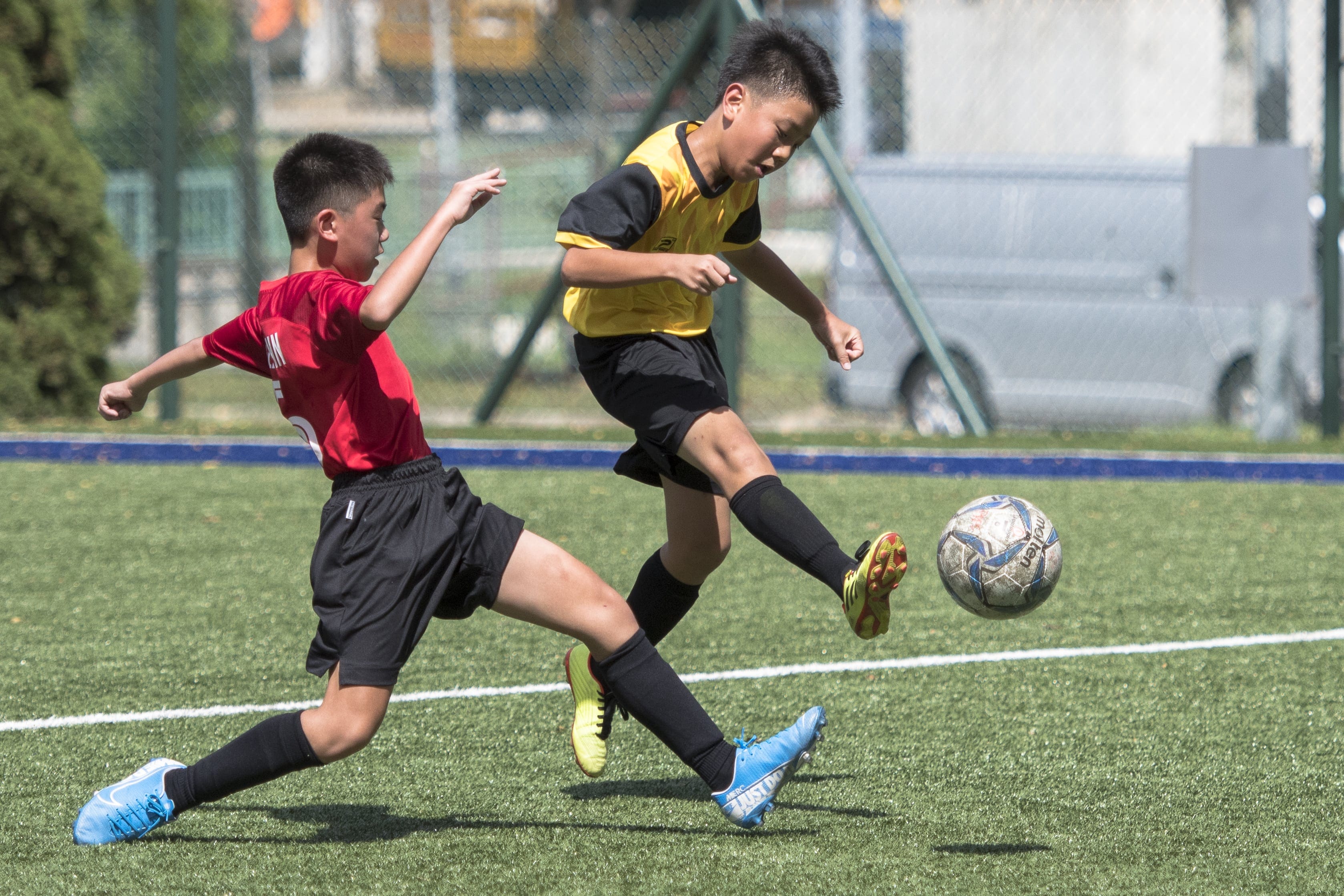 Our SKG boys playing soccer on a green turf field.