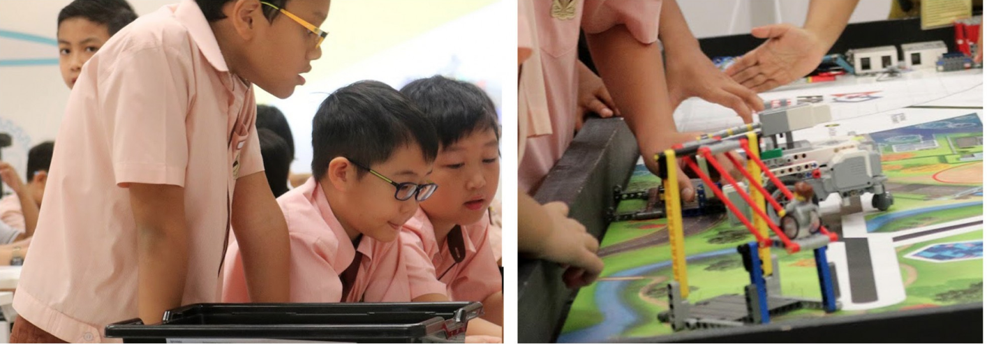 Students look at a tablet and interact with a colorful Lego robot on a competition mat.