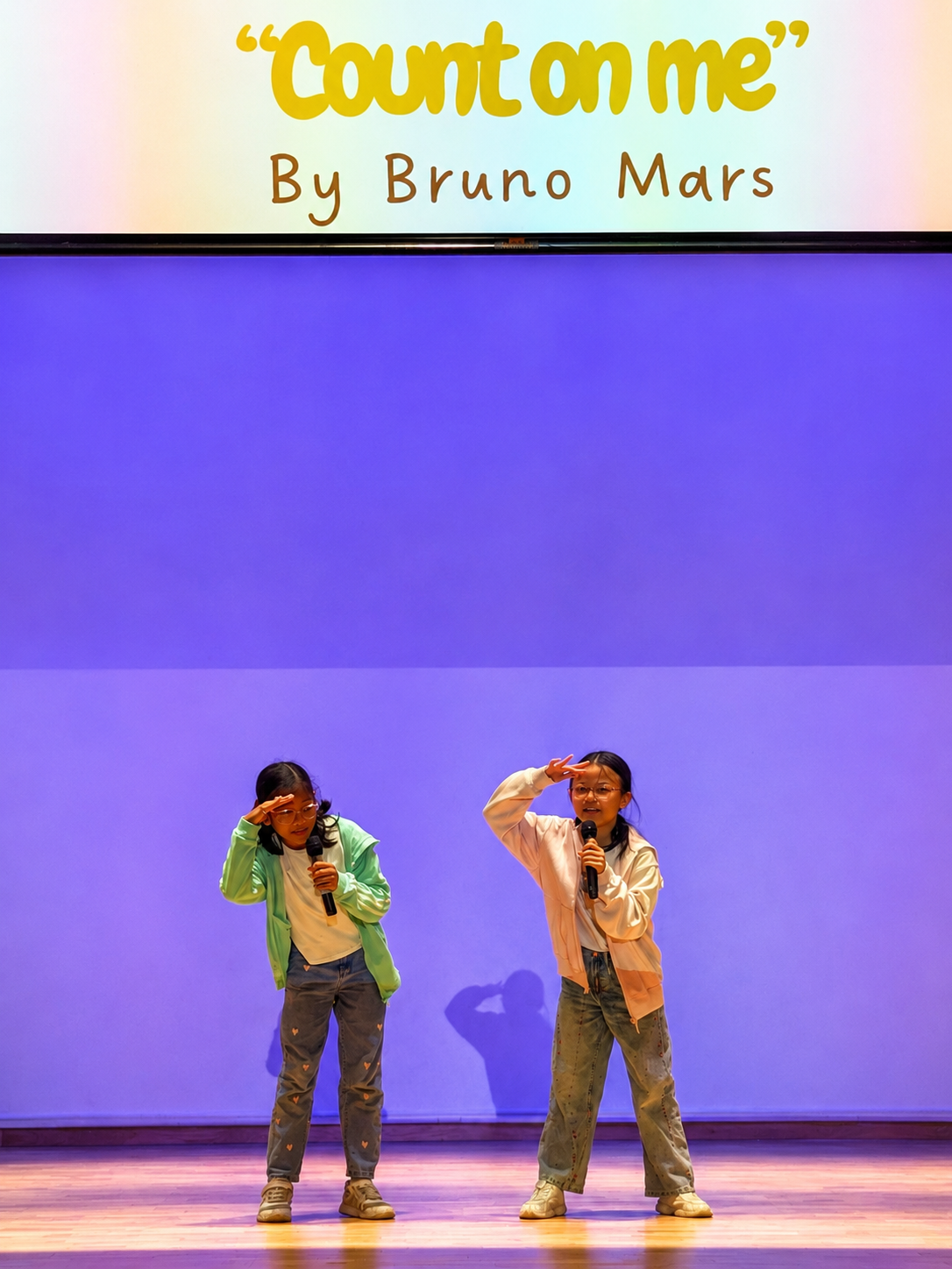 Two students performing with a projected backdrop.
