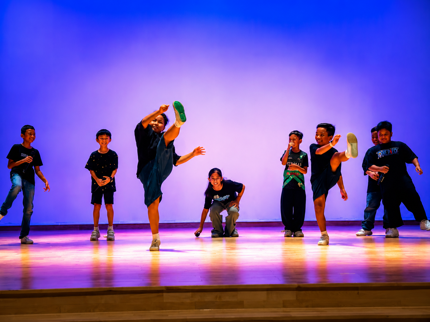 Group performance with students dancing on stage.