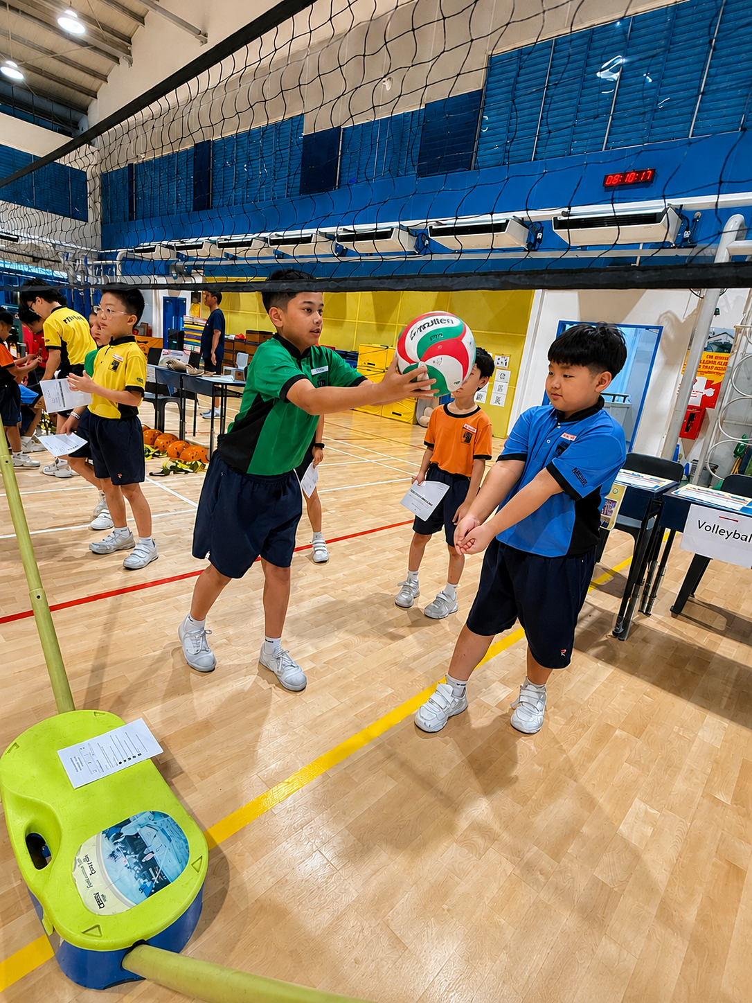 Students doing a high-five in a circle in an indoor hall.