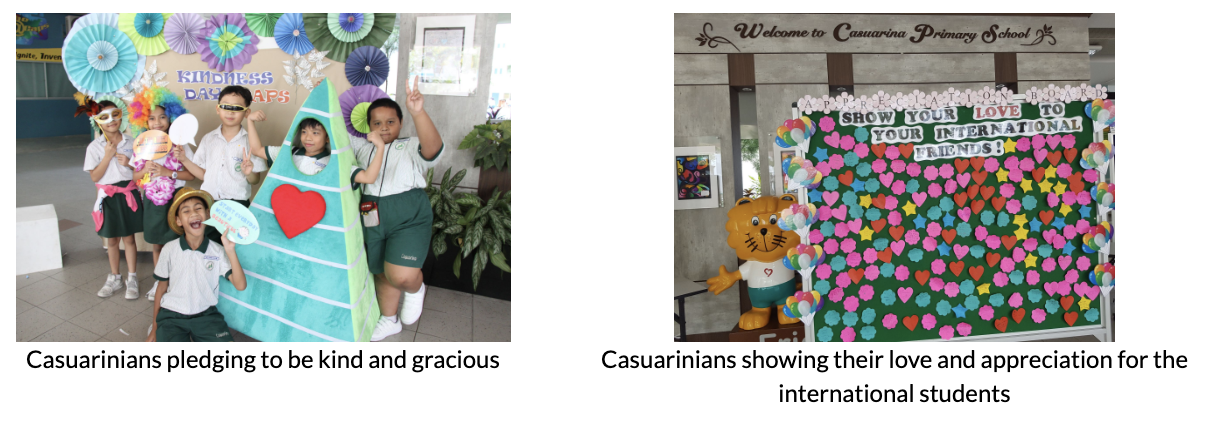Students pose at a Kindness Day display beside a colorful board covered in paper hearts at Casuarina Primary School.