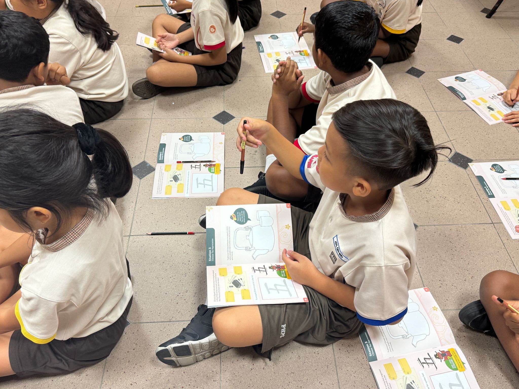 Students writing out the Chinese characters using calligraphy techniques