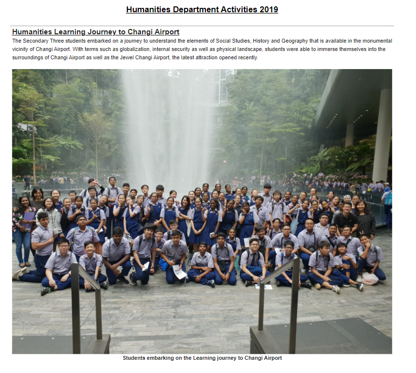 A large group of students in school uniforms posing in front of a tall indoor waterfall at Jewel Changi Airport.