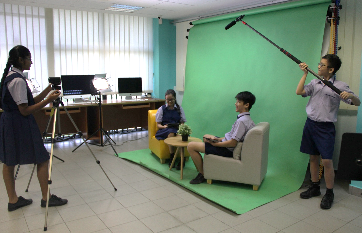 A group of Secondary 2 students demonstrating how videography with Chroma Key effect is being produced