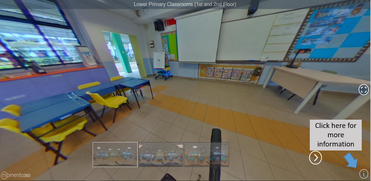 360-degree view of a primary school classroom with blue desks, yellow chairs, whiteboards, and colorful bulletin boards.