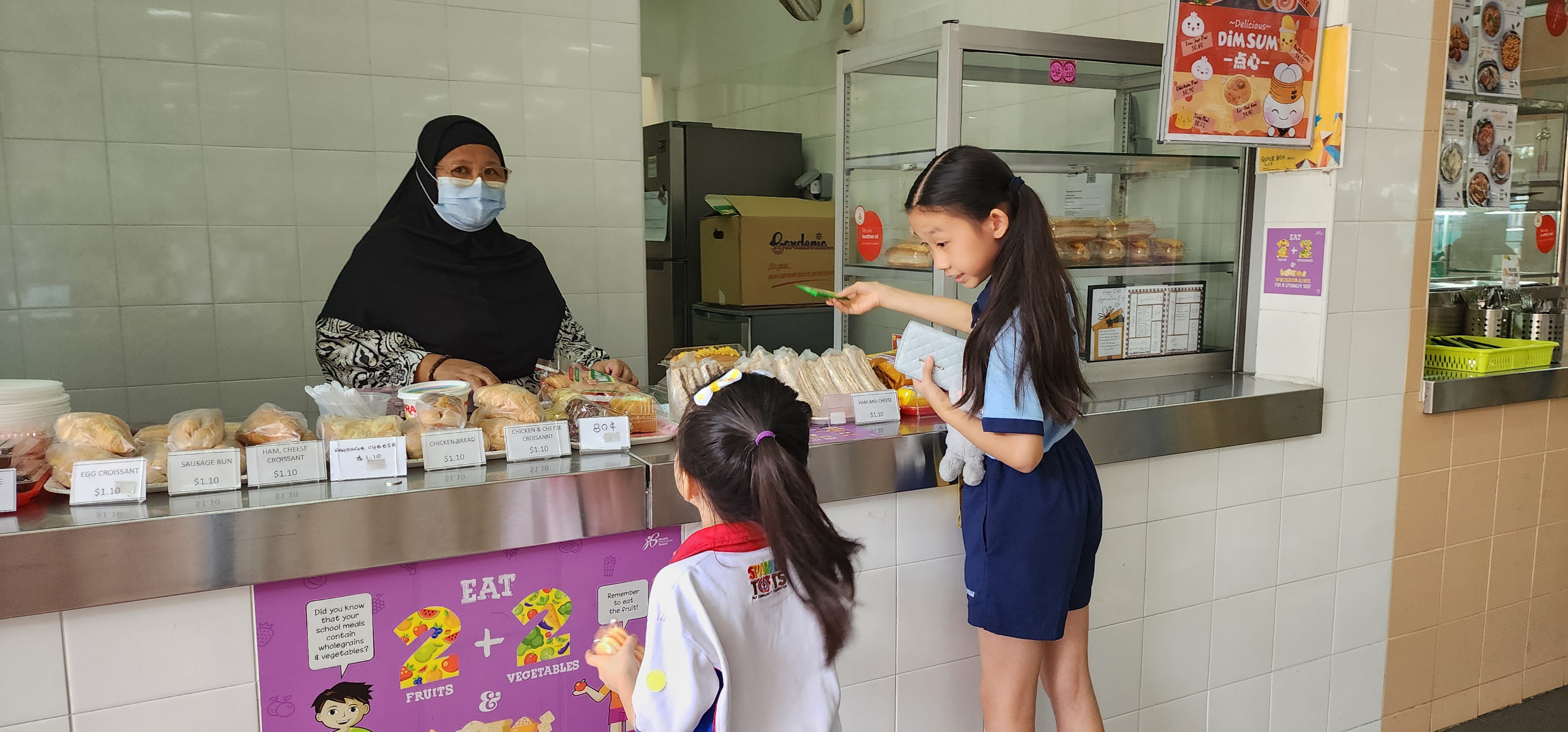 Student leaders bring the preschoolers to buy food at a canteen.