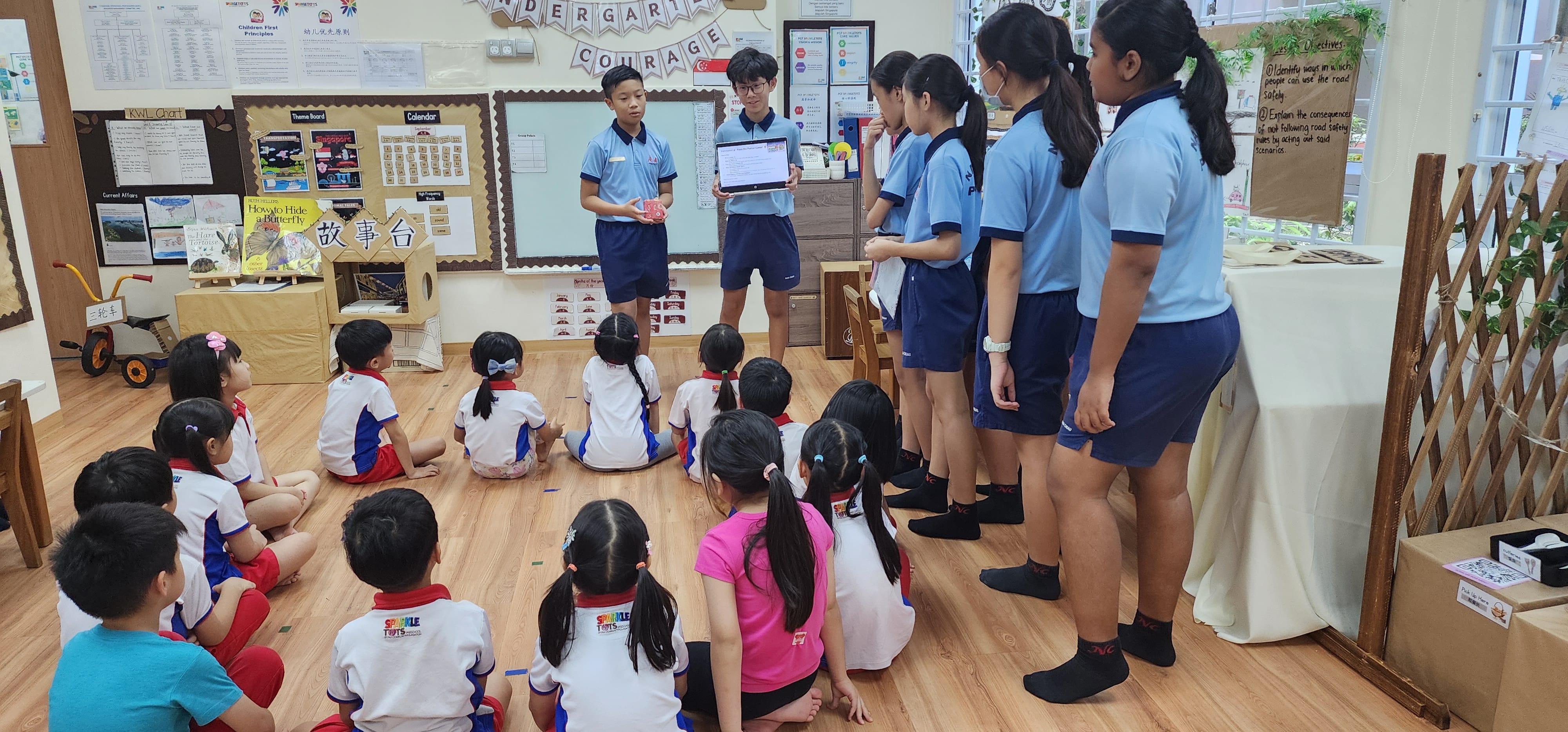 Student leaders telling stories to the preschoolers.