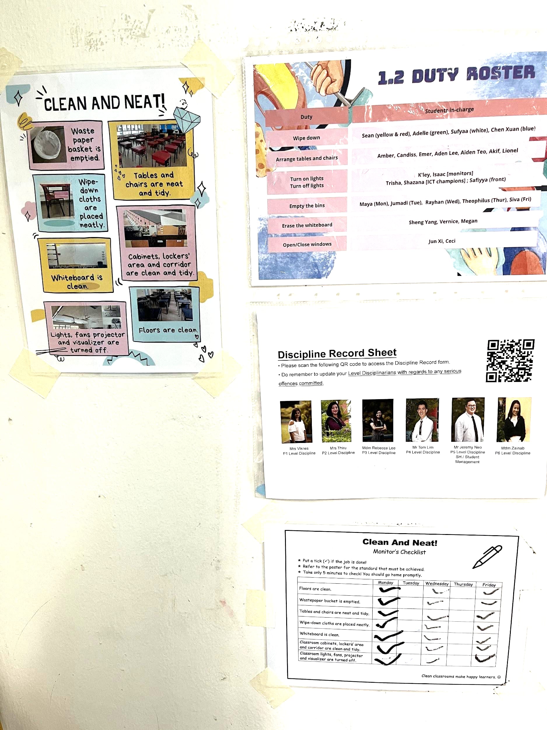 Wall with taped posters: Clean and Neat checklist, duty roster, discipline record sheet, and a ticked table.