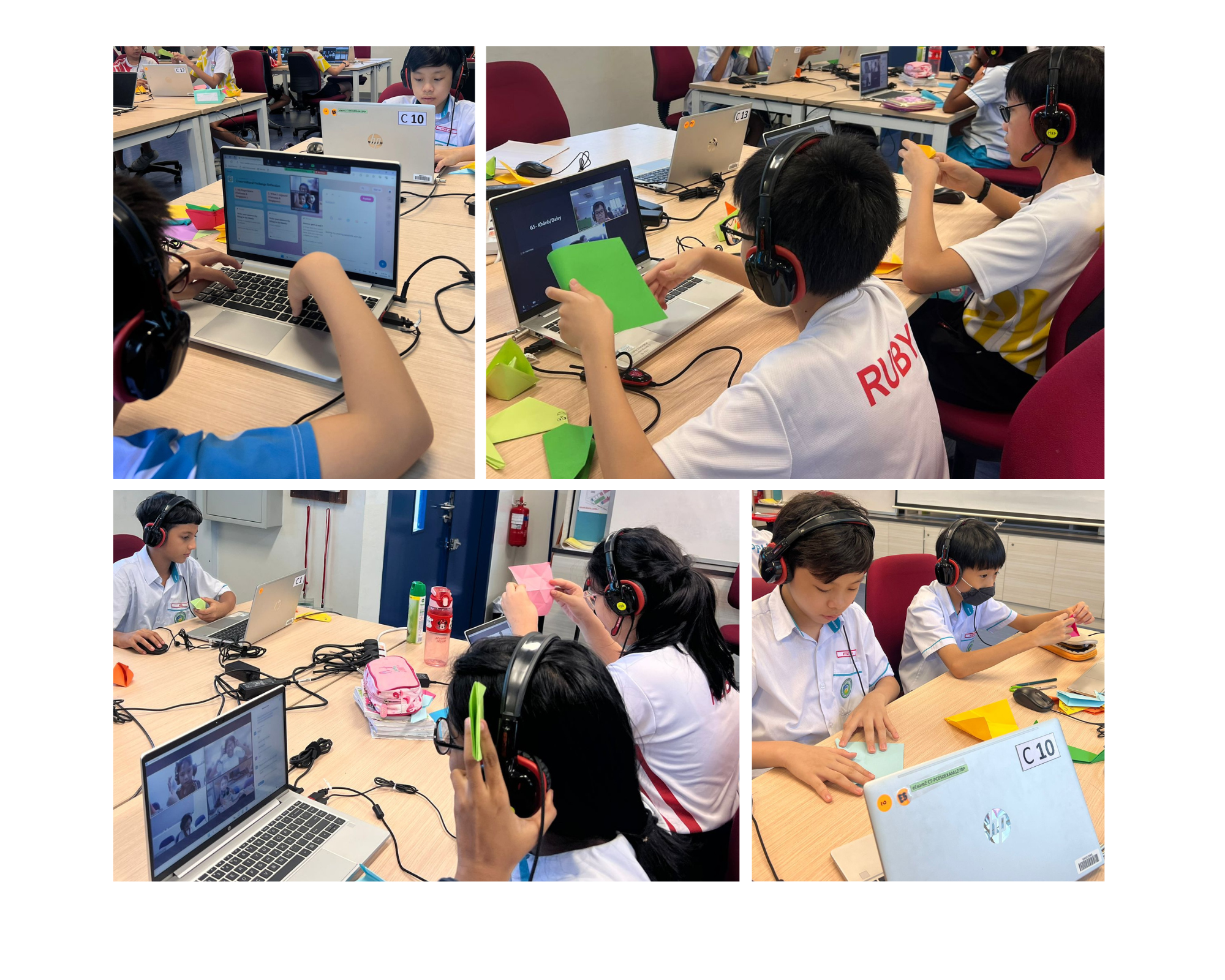 Students wearing headphones use laptops for a video call while handling colorful paper in a classroom.