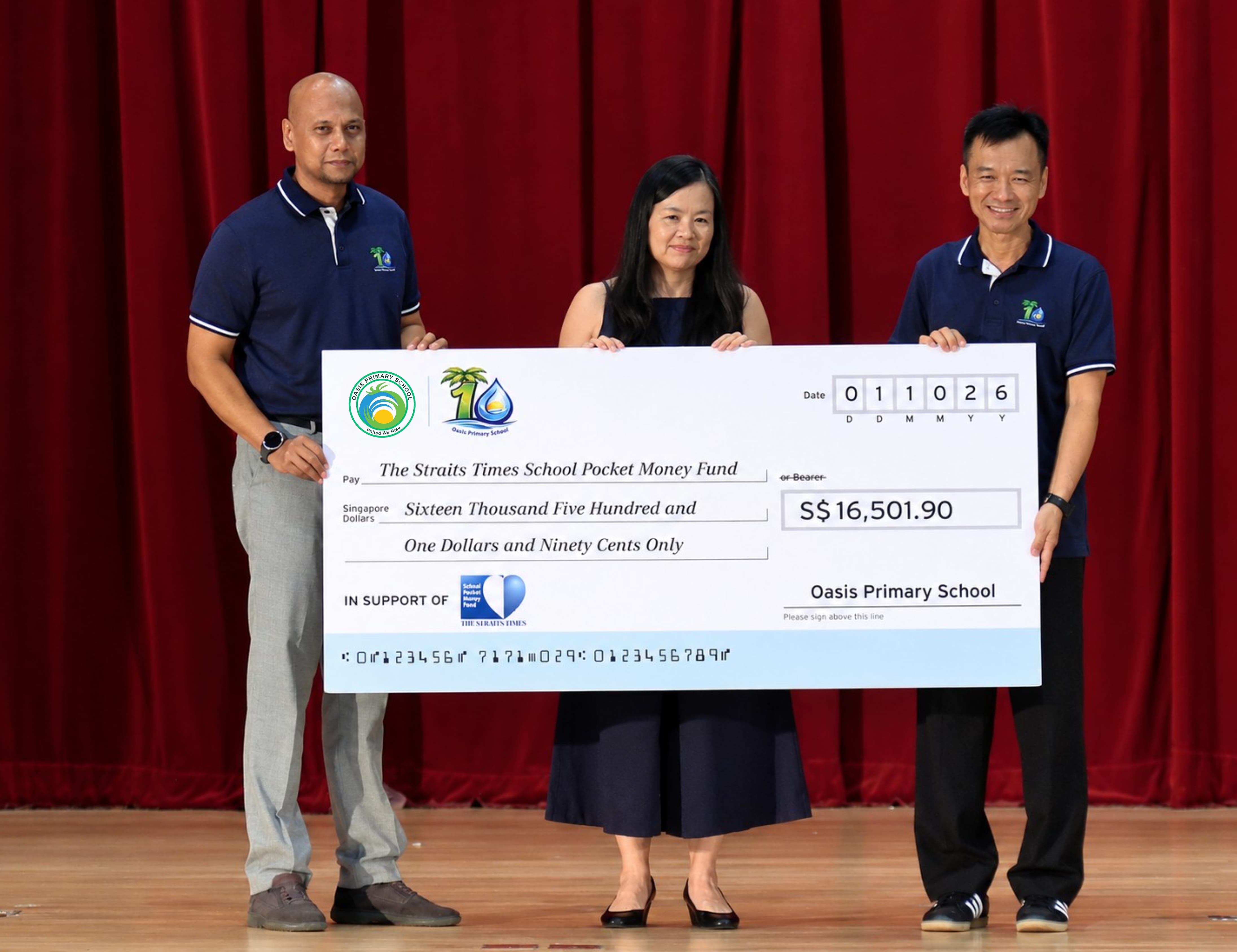 Three people hold a S$16,501.90 cheque for Oasis Primary School.