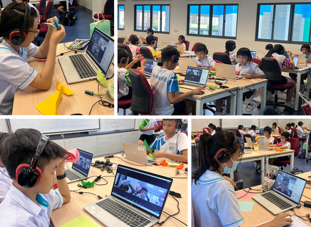 Students wearing headphones work on laptops in a classroom, participating in video calls while handling colorful paper crafts.