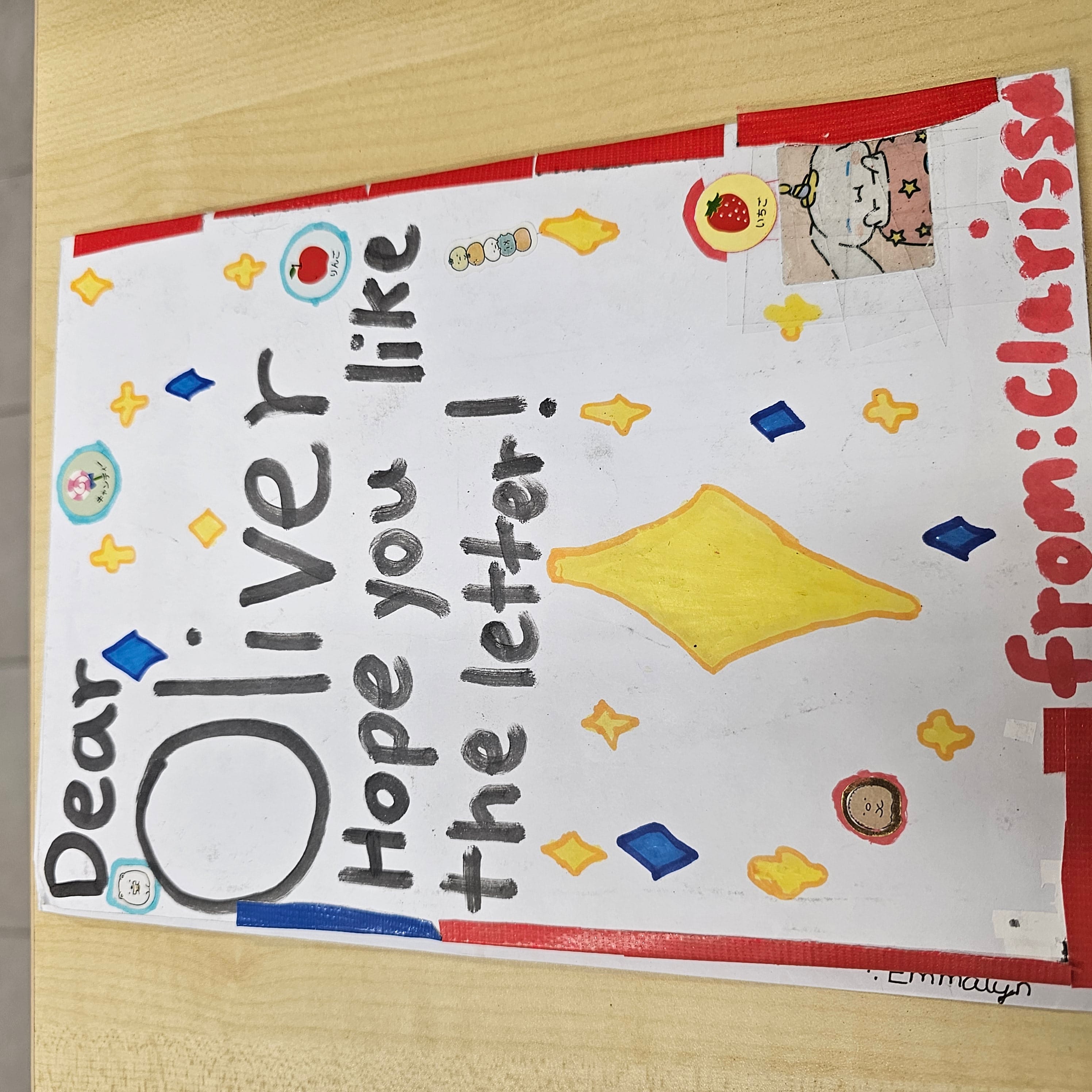 Handwritten card addressed "Dear Oliver, Hope you like the letter!" signed "from: Clarissa" with colorful stickers and drawings.