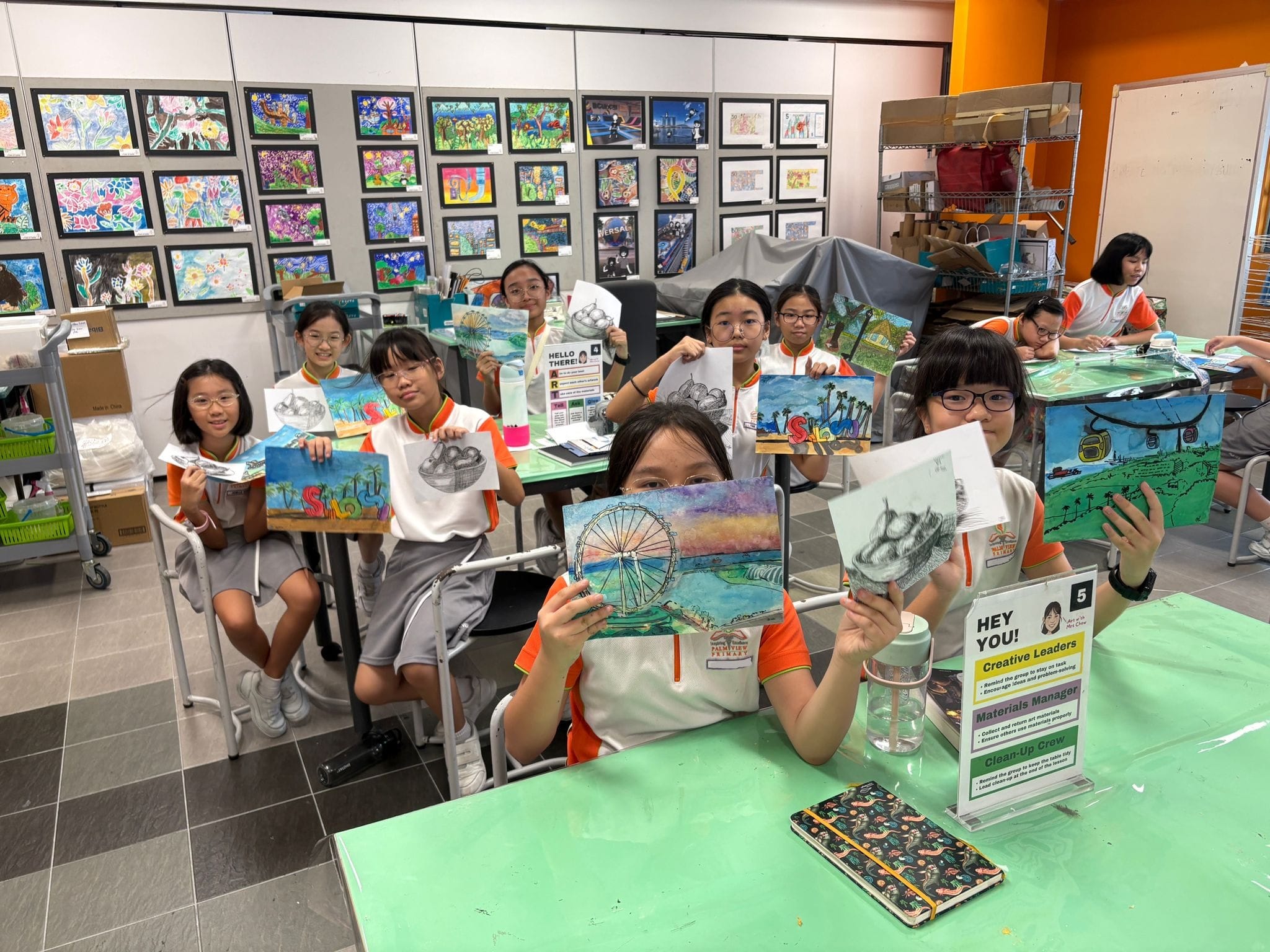 Students smiling while holding up their watercolour & pen ink artworks
