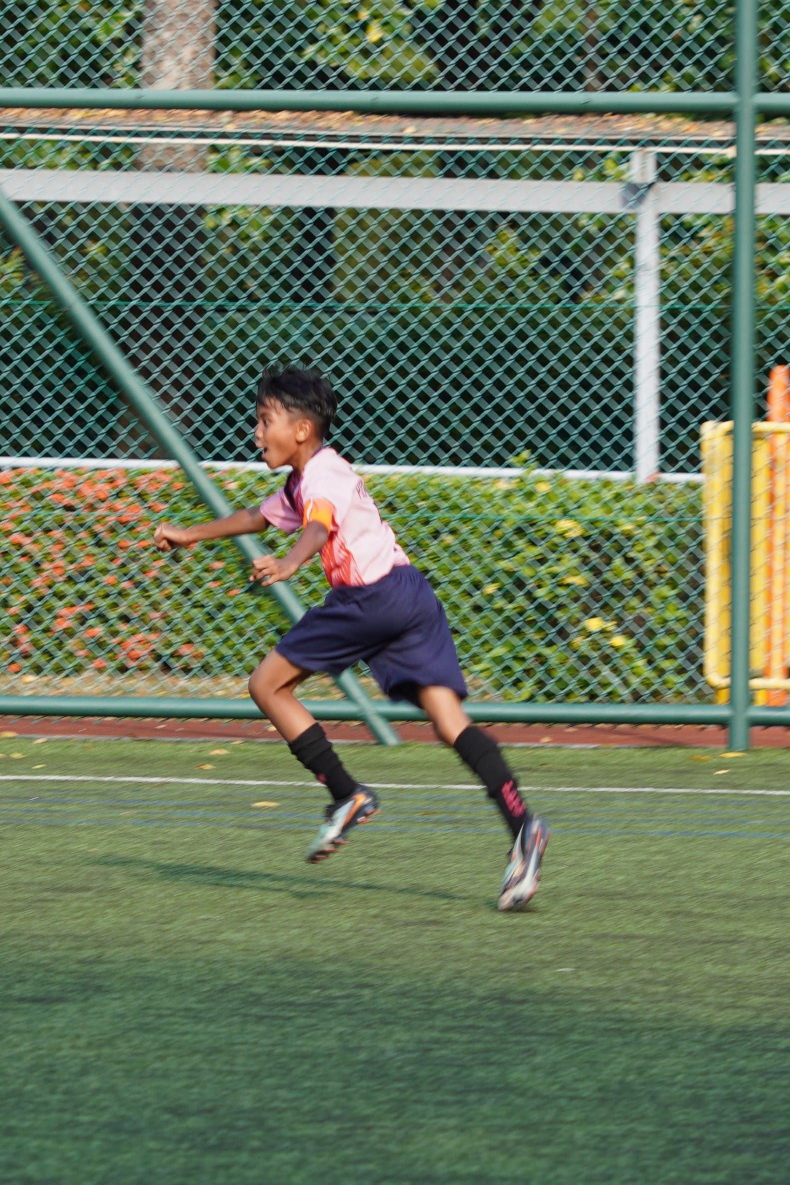 Boy in football jersey running on the football field