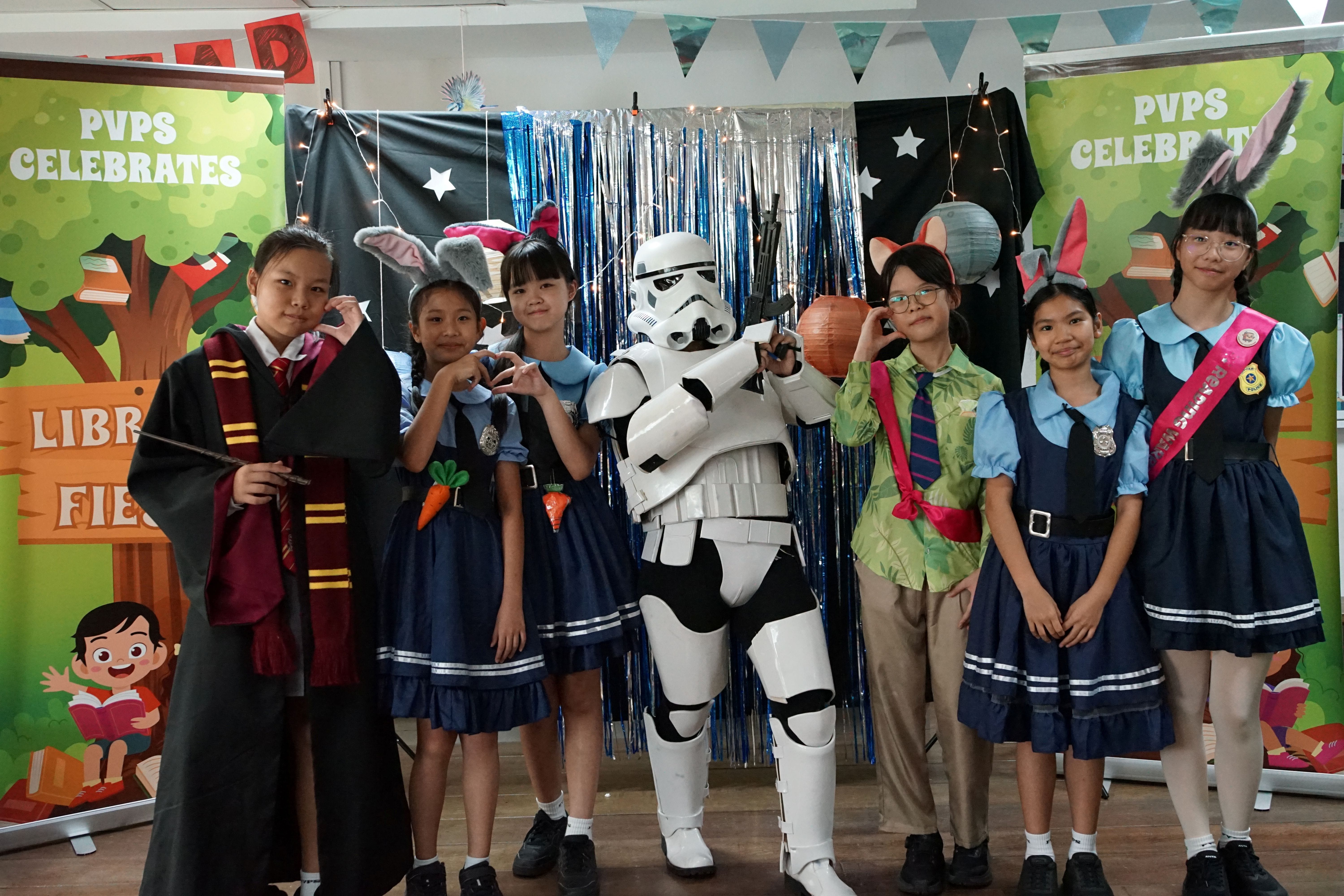 Students dressed up as their facvourite characters at a photobooth in the library during recess activity on library fiesta week