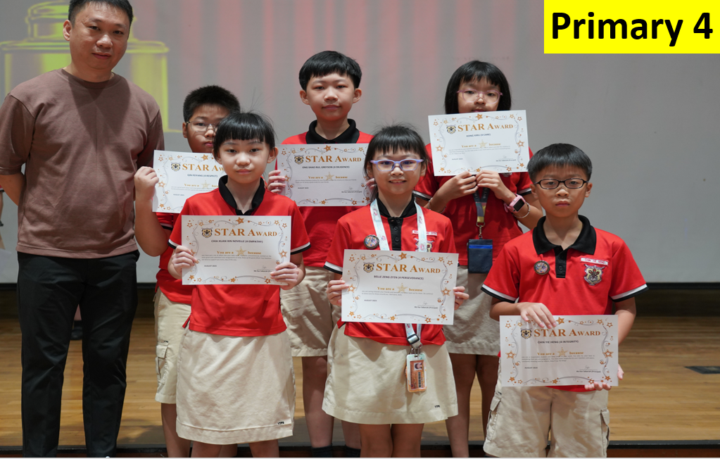 Six Primary 4 students in red uniforms hold Star Award certificates, standing with an adult male on a stage.