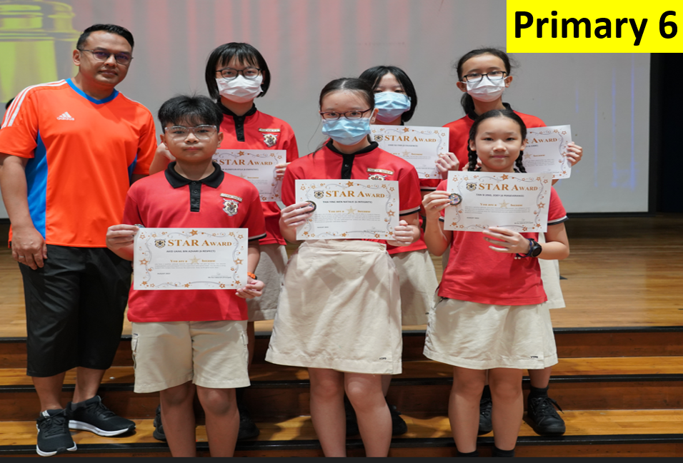 Six Primary 6 students in red uniforms hold Star Award certificates, standing with a teacher in an orange shirt.