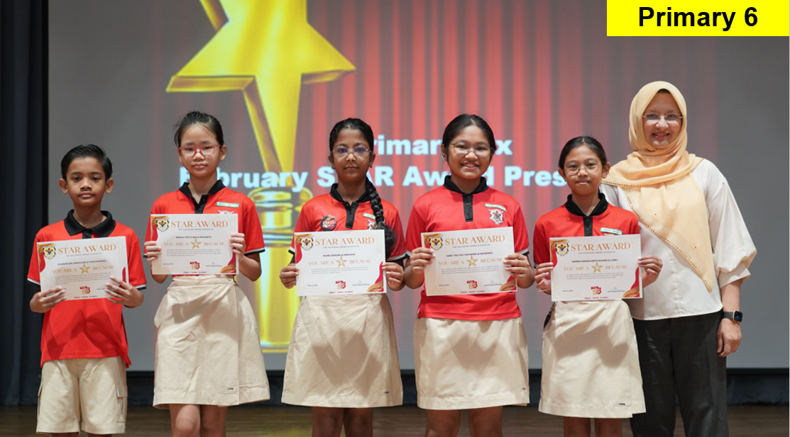 Five Primary 6 students in red uniforms hold Star Award certificates on stage beside a teacher in a hijab.