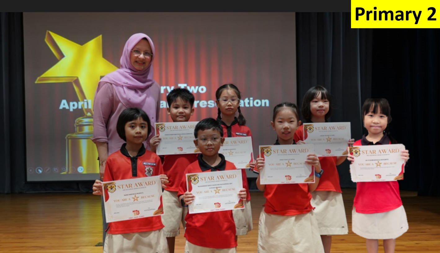 Six young students in red uniforms hold Star Award certificates while posing with a teacher on a stage.
