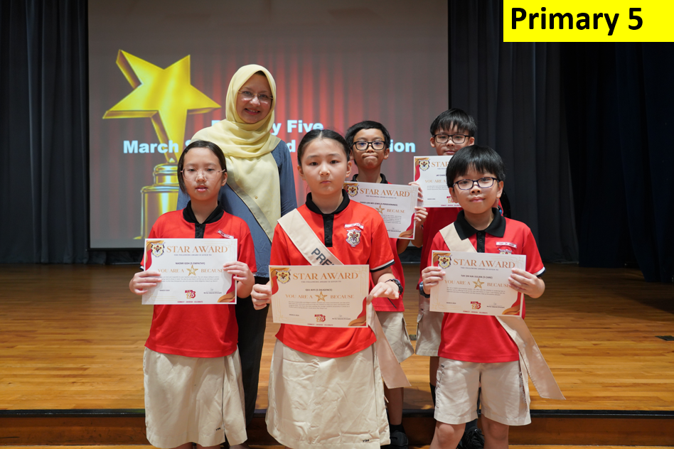 Five Primary 5 students in red uniforms hold Star Award certificates, posing with a teacher on a stage.