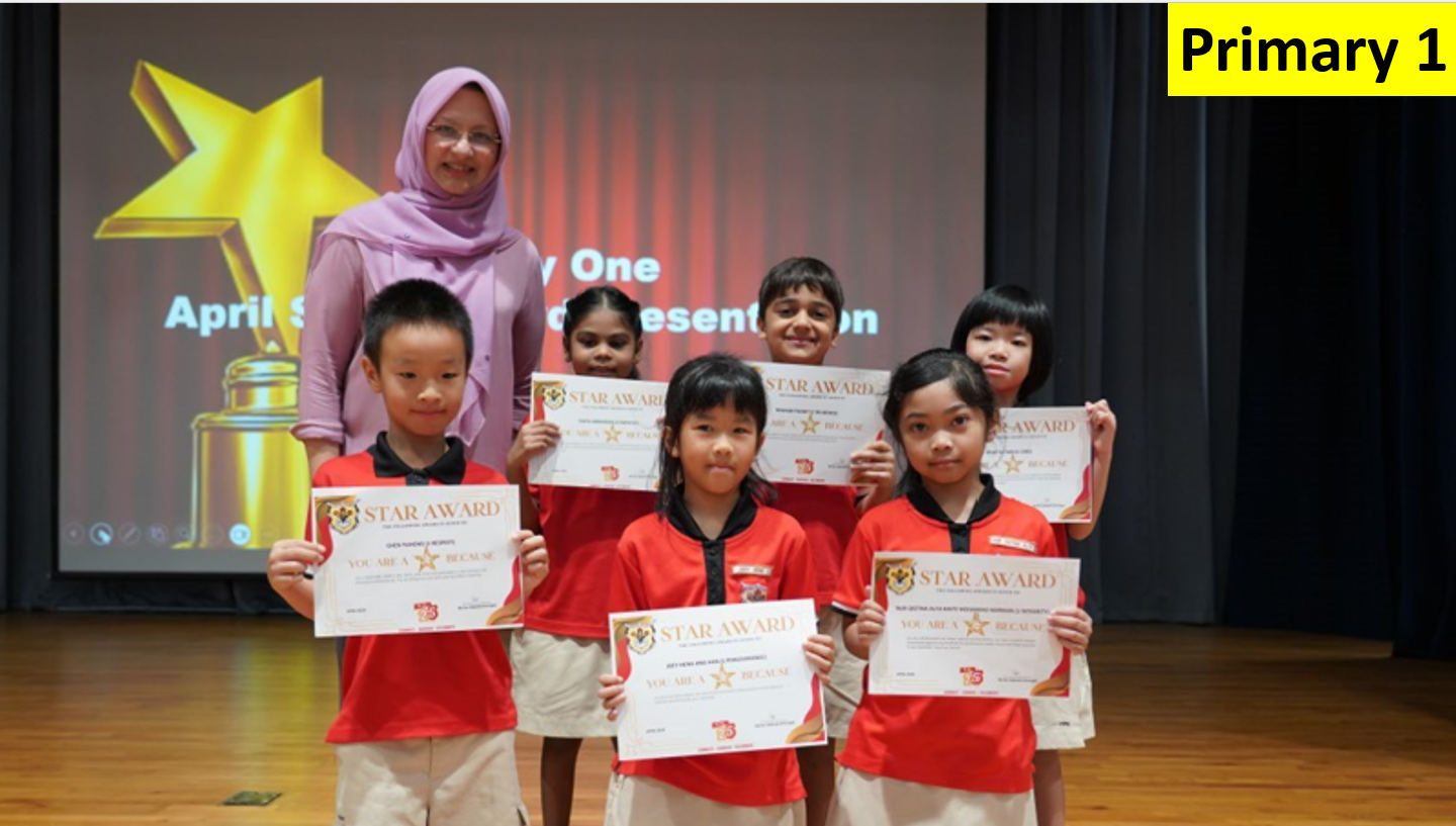 Six young students in red uniforms hold Star Award certificates, standing with a teacher on a stage.