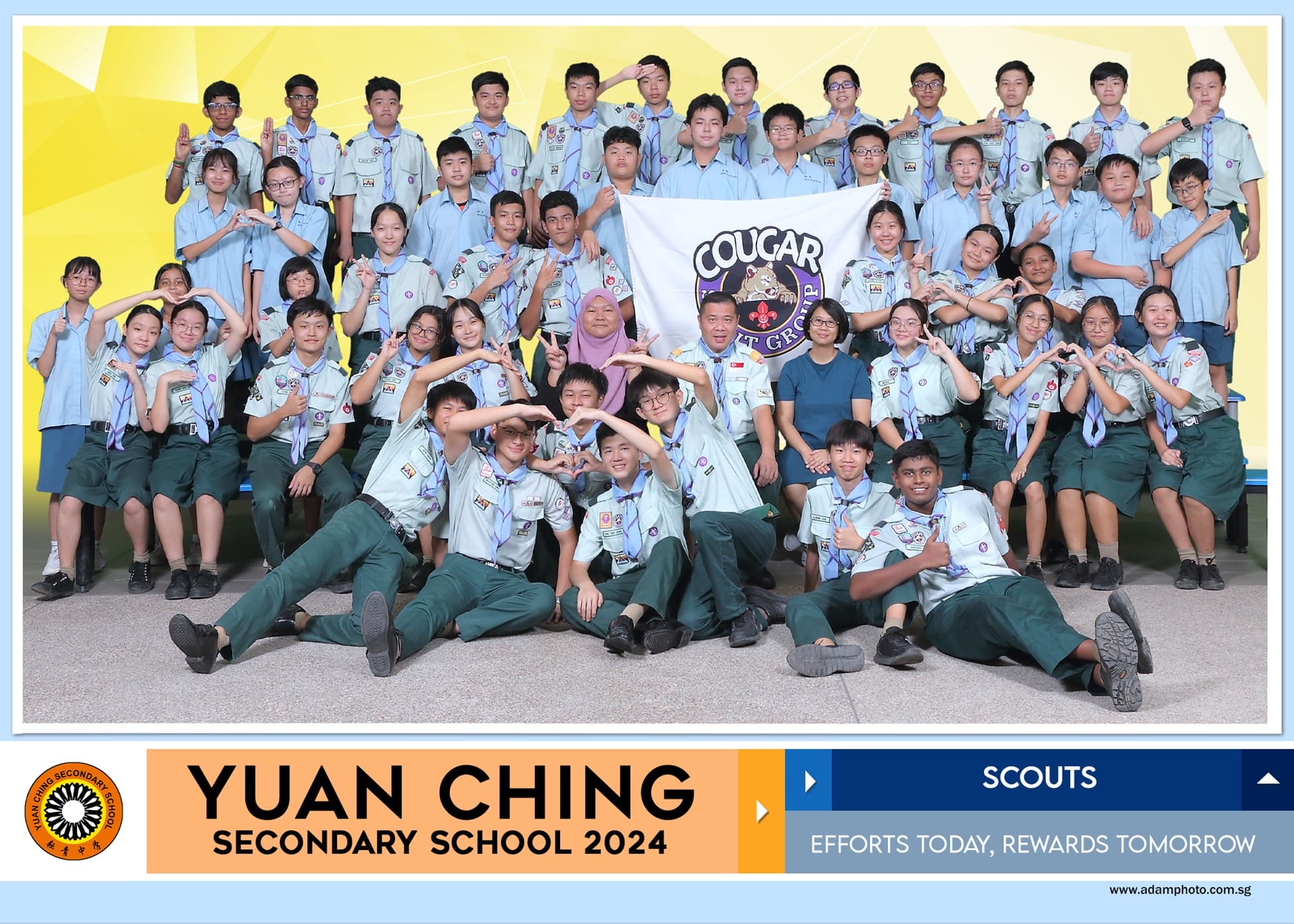 Large group of students in scout uniforms posing with a Cougar Scout Group flag for Yuan Ching Secondary School 2024.