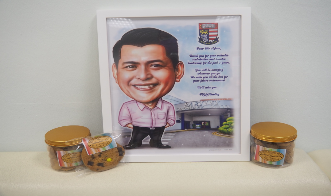 Framed caricature of a smiling man with a farewell letter, flanked by two cookie jars and packaged cookies on a shelf.