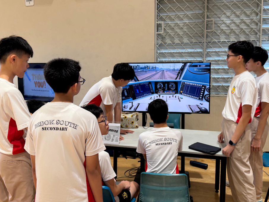 Students from the Overengineered interest group sharing the Arduino-powered game console they built with their peers at Passion Day 2026.