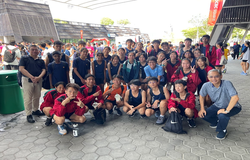 Bedok View students and staff posing together outdoors at a sporting event near OCBC Square.