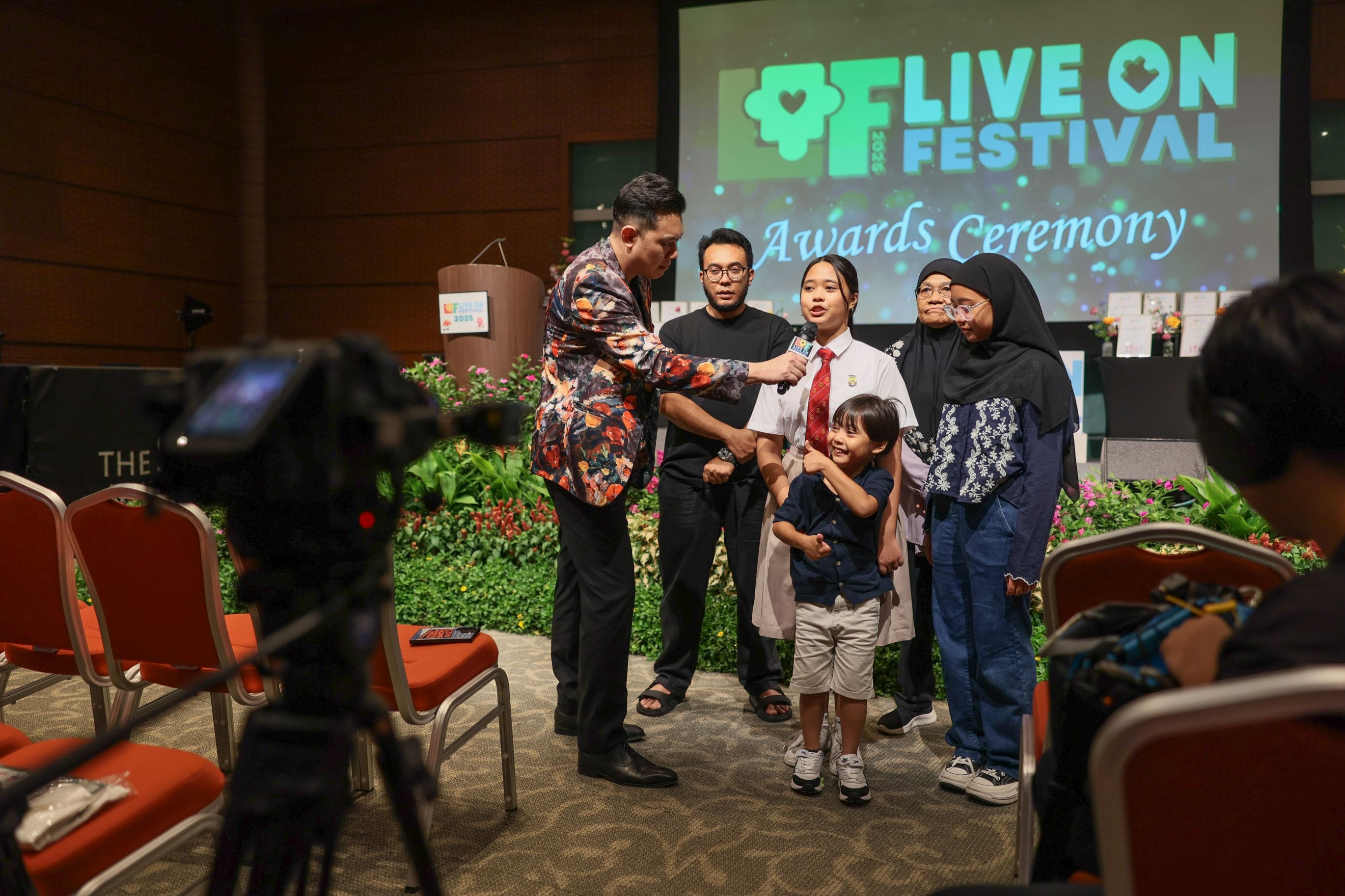 The emcee of the Awards Ceremony interviewing a winner and her family