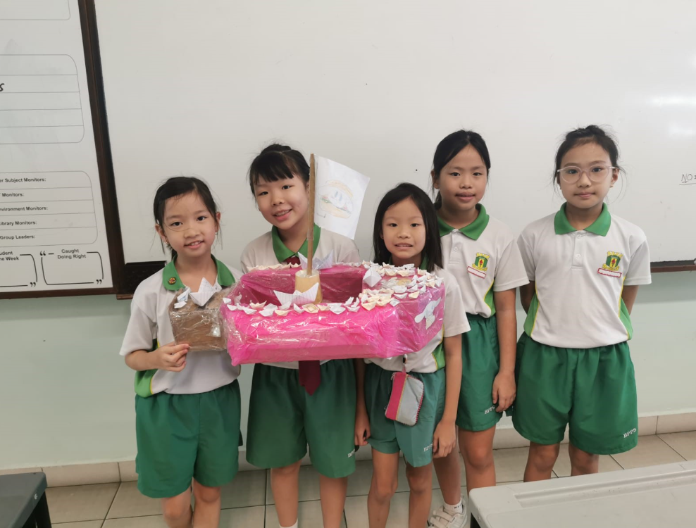 A group of students posing with their boat project