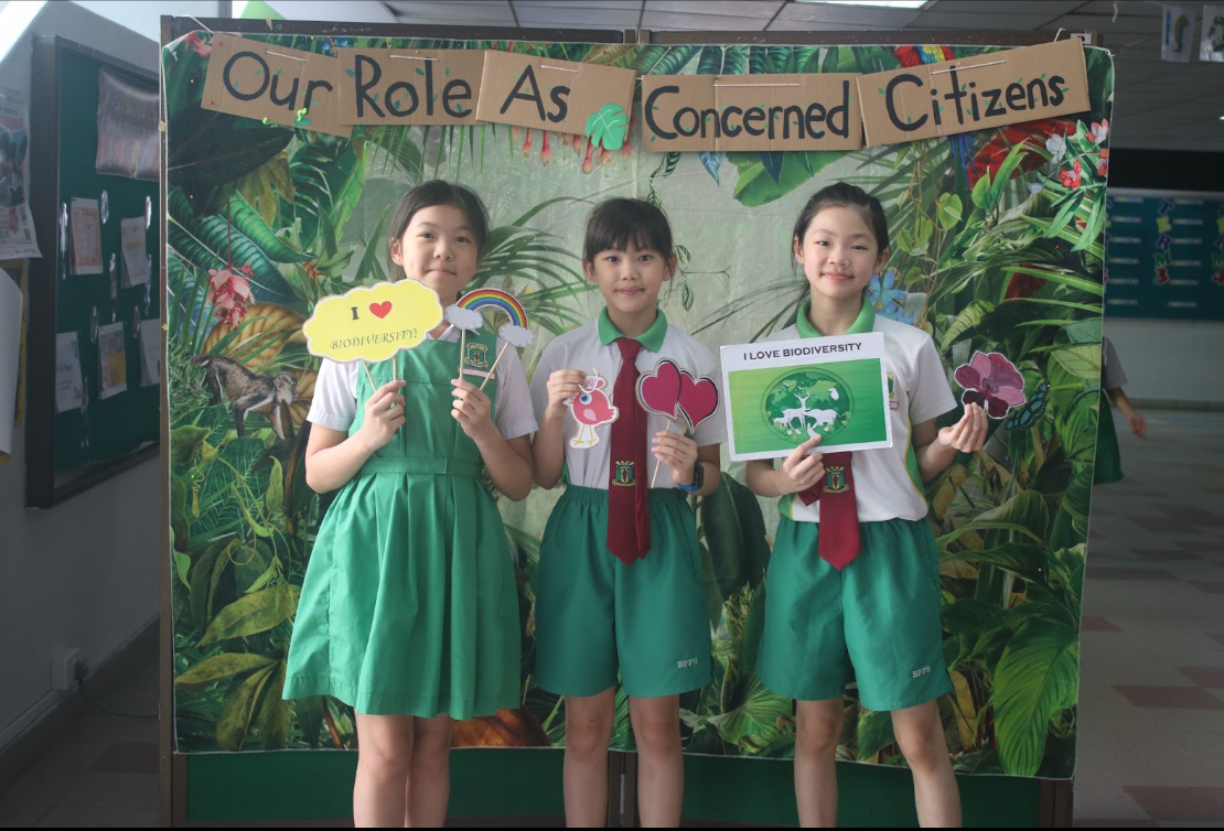 students posing at a photo booth , holding place cards 6