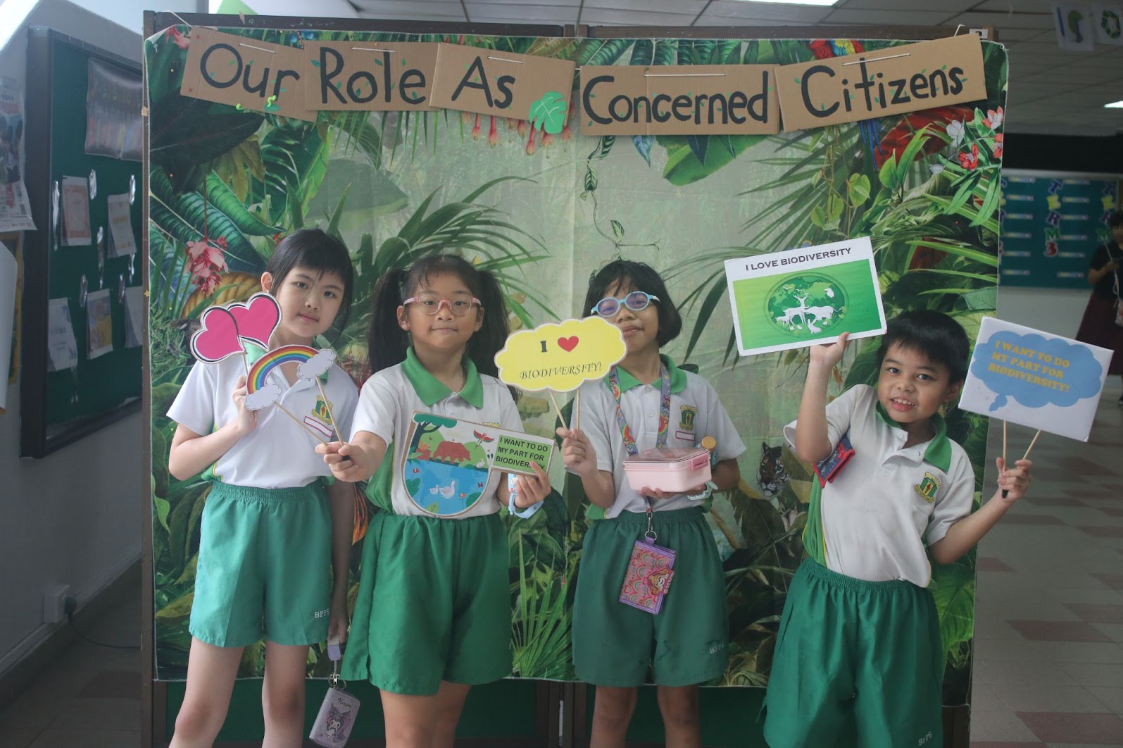 students posing at a photo booth , holding place cards 5