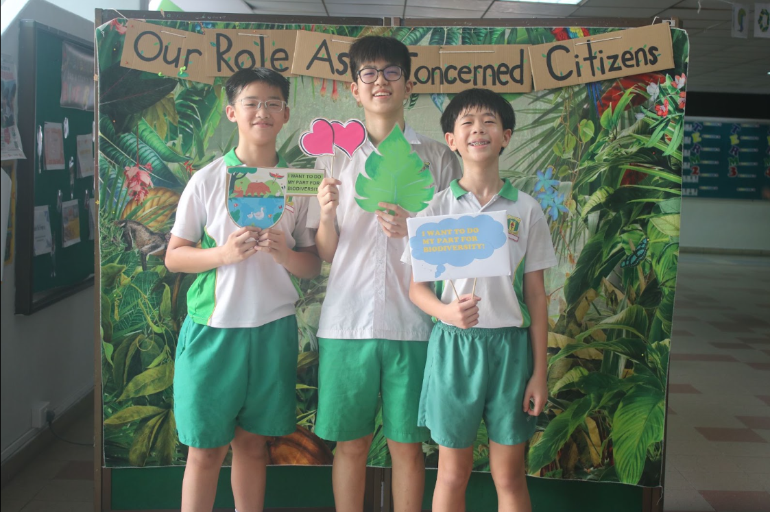 students posing at a photo booth , holding place cards 4