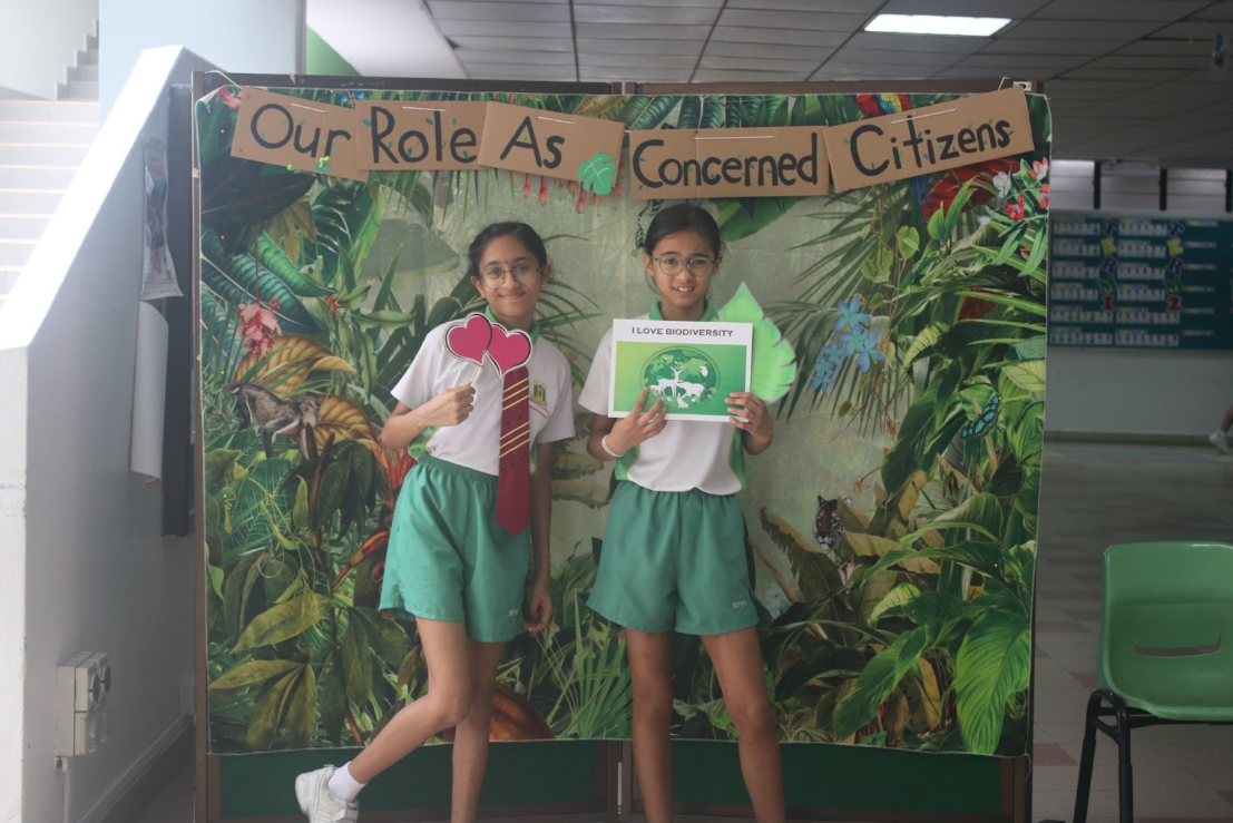 students posing at a photo booth , holding place cards 3