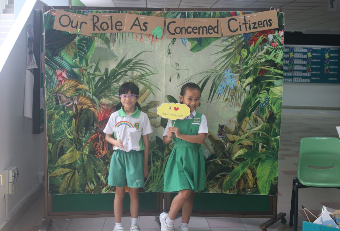 students posing at a photo booth , holding place cards 2