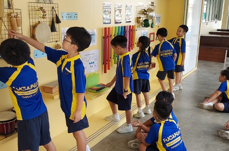Students exploring and playing musical instruments during a hands-on learning activity.